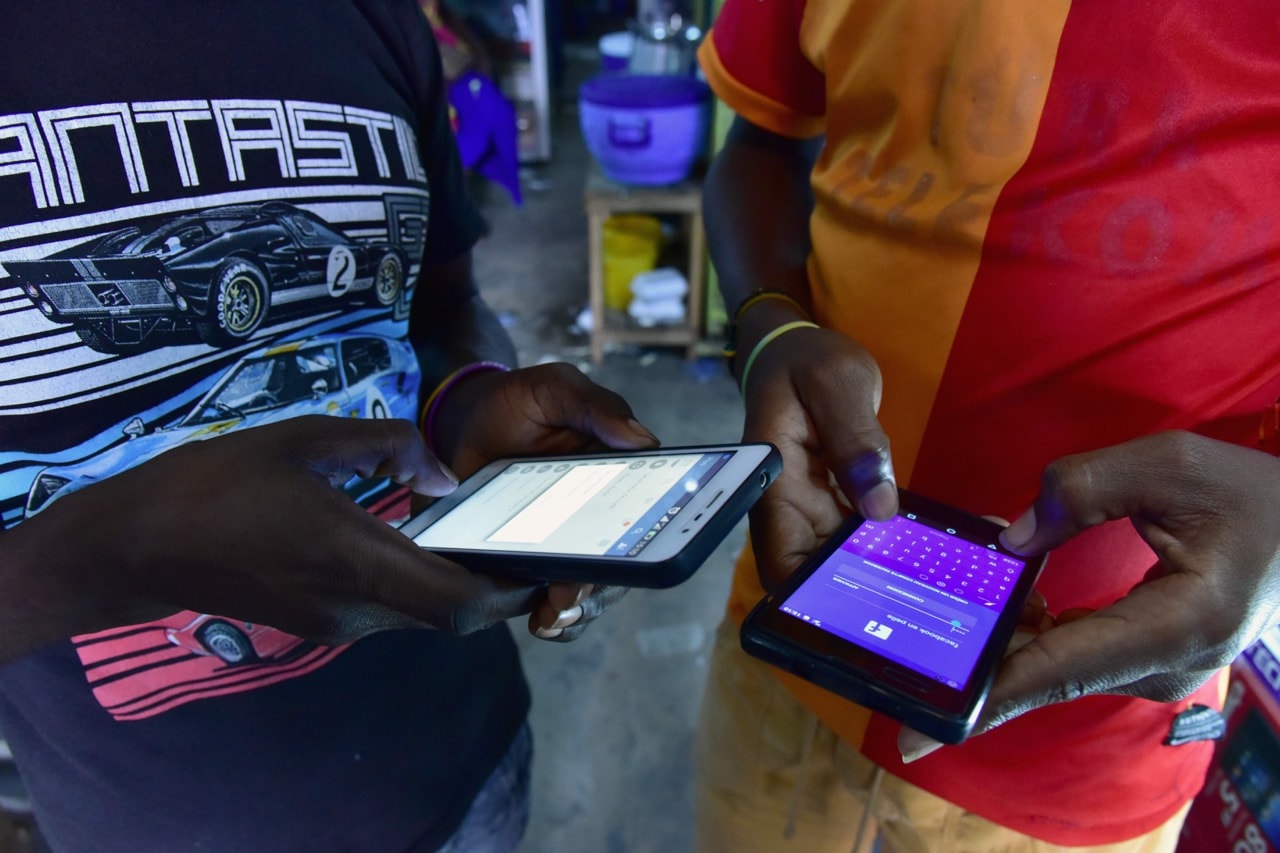 People browse internet articles the new version of Facebook in the West African language Peule, in Abidjan, Cote d'Ivoire, 30 September 2016, ISSOUF SANOGO/AFP/Getty Images