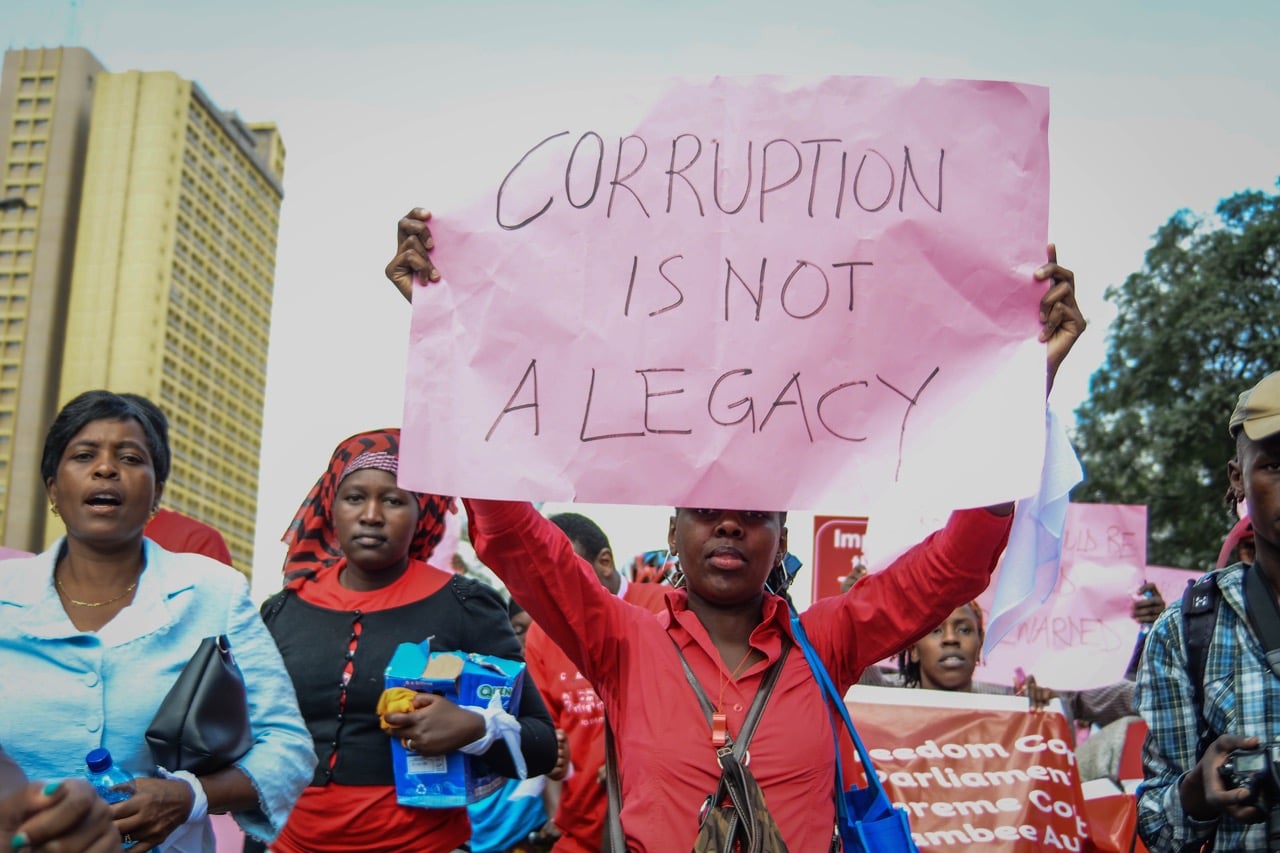 A protestor carries a placard as Kenyans took to the streets to call on the government to arrest people involved in massive corruption scandals, Nairobi, Kenya, 31 May 2018, Allan Muturi/SOPA Images/LightRocket via Getty Images