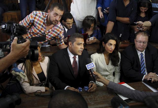 Al Jazeera television journalists Mohamed Fahmy, C, and Baher Mohamed, L, talk to the media with lawyer Amal Clooney (R) before hearing the verdict at a court in Cairo, Egypt, August 29, 2015, REUTERS/Asmaa Waguih
