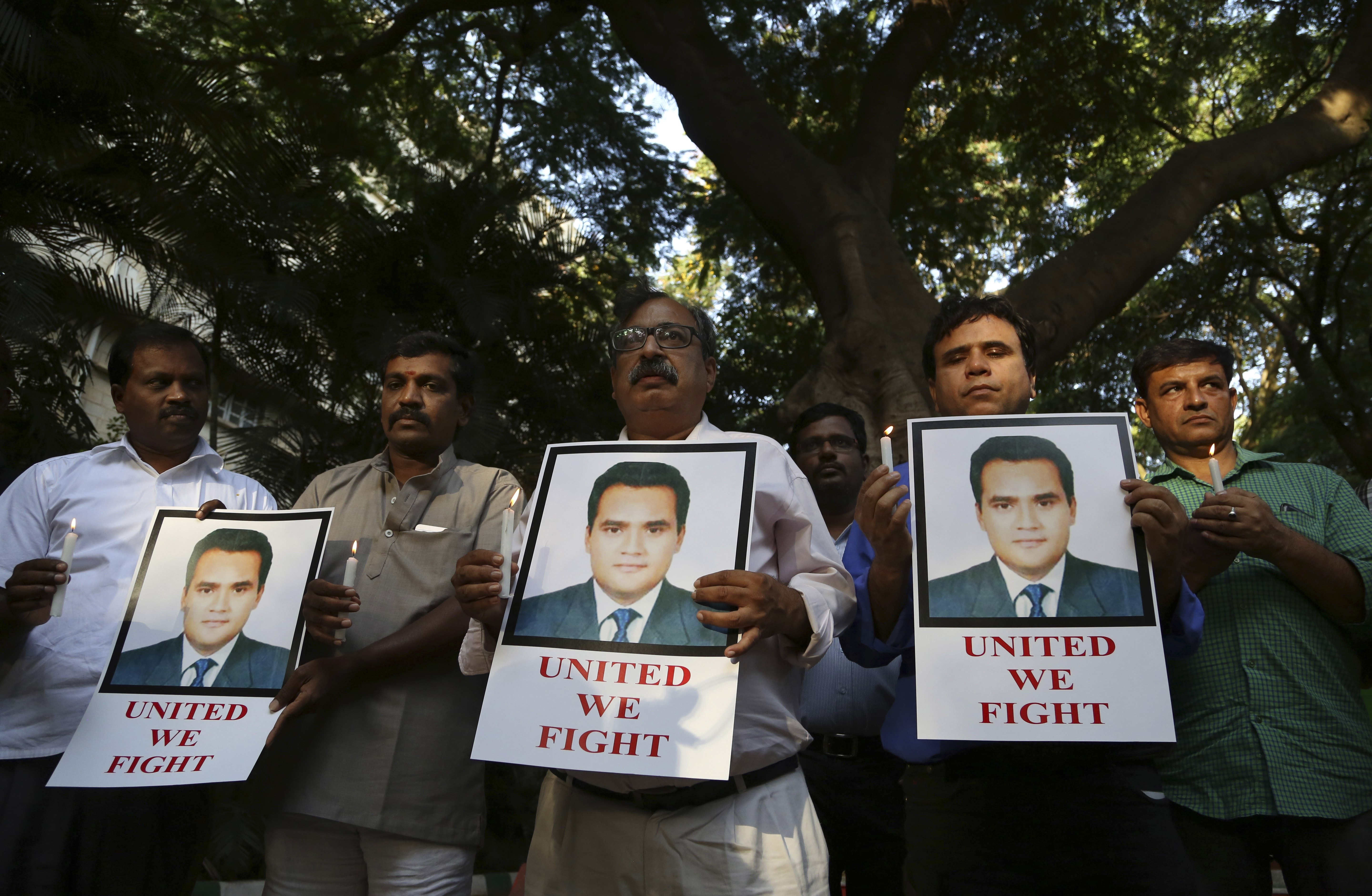 Indian journalists hold candles and photographs of Akshay Singh during a memorial meeting in Bangalore, India, on 6 July 2015, AP Photo/Aijaz Rahi