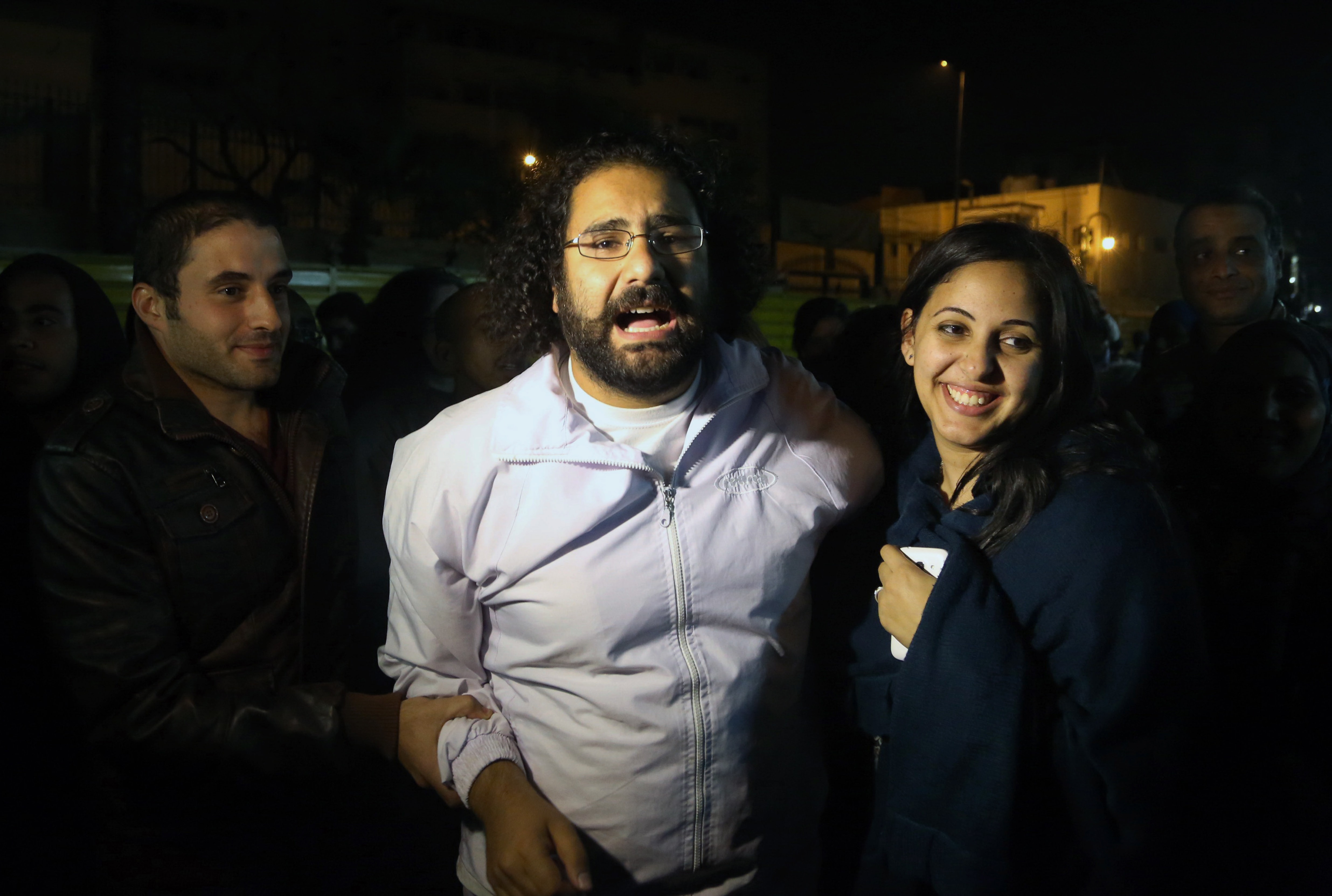 Alaa Abd El Fattah, center in white, is welcomed by his wife after he was released from the main central security office in Cairo on 23 March 2014, AP Photo/Roger Anis, El Shorouk Newspaper