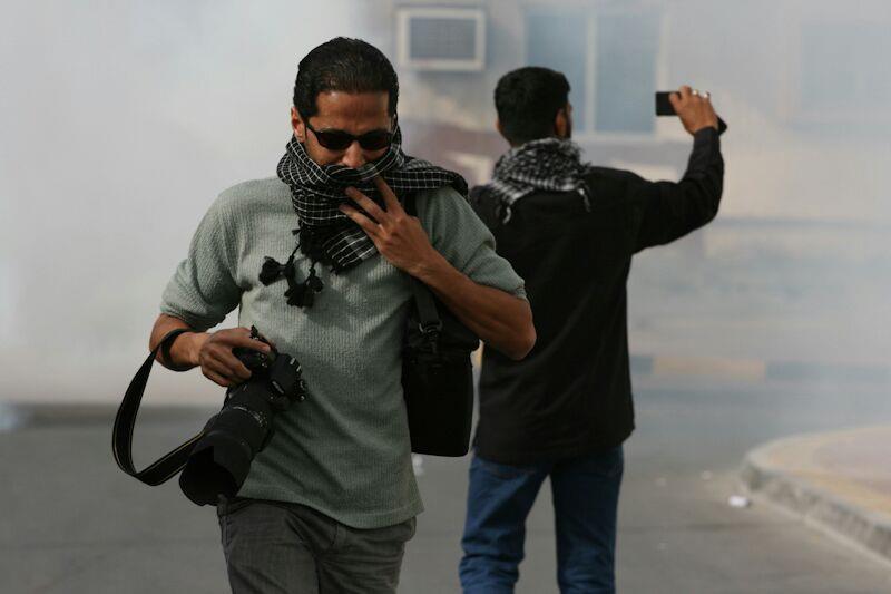 Ammar Abdulrasool covering his face from teargas , Ammar Abdulrasool/Facebook