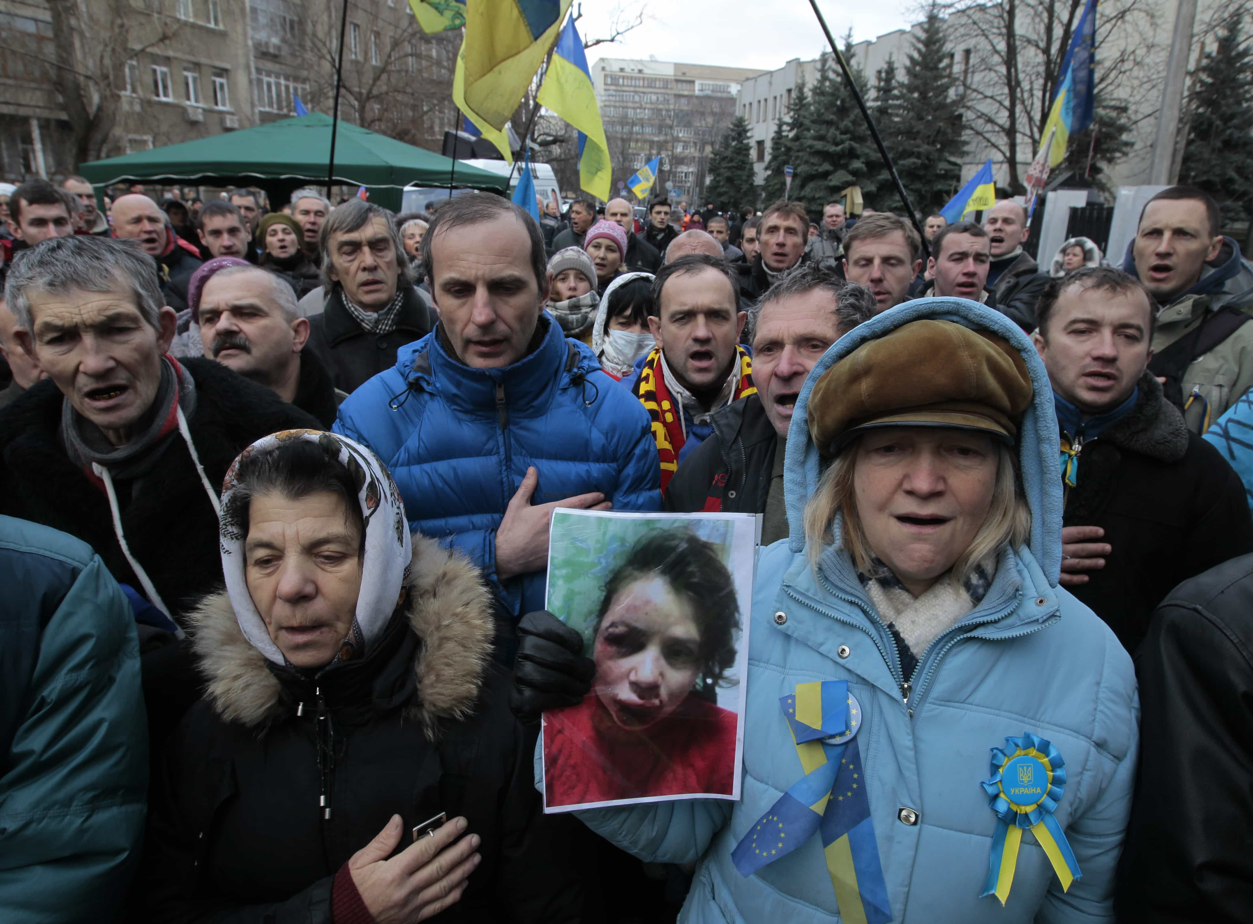 Activists hold the photo of journalist and activist Tatiana Chornovol as they rally outside the Ukrainian Interior Ministry in Kiev, Ukraine, 25 December 2013., AP Photo/Sergei Chuzavkov