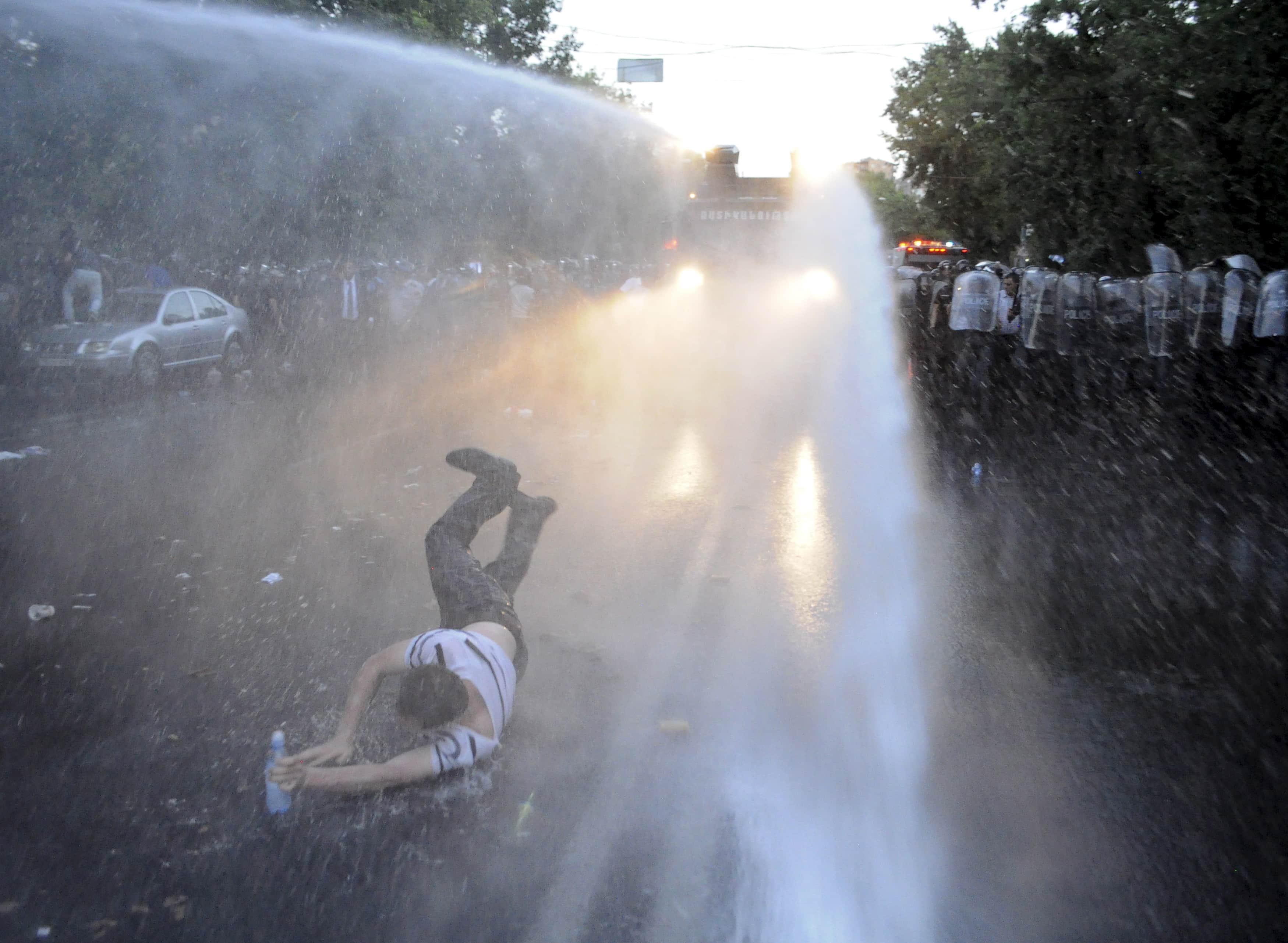 A protester is hit by a jet of water released from a riot police vehicle during a rally against a recent decision to increase the tariff on electricity, in Yerevan, 23 June 2015,  REUTERS/Narek Aleksanyan/PAN Photo