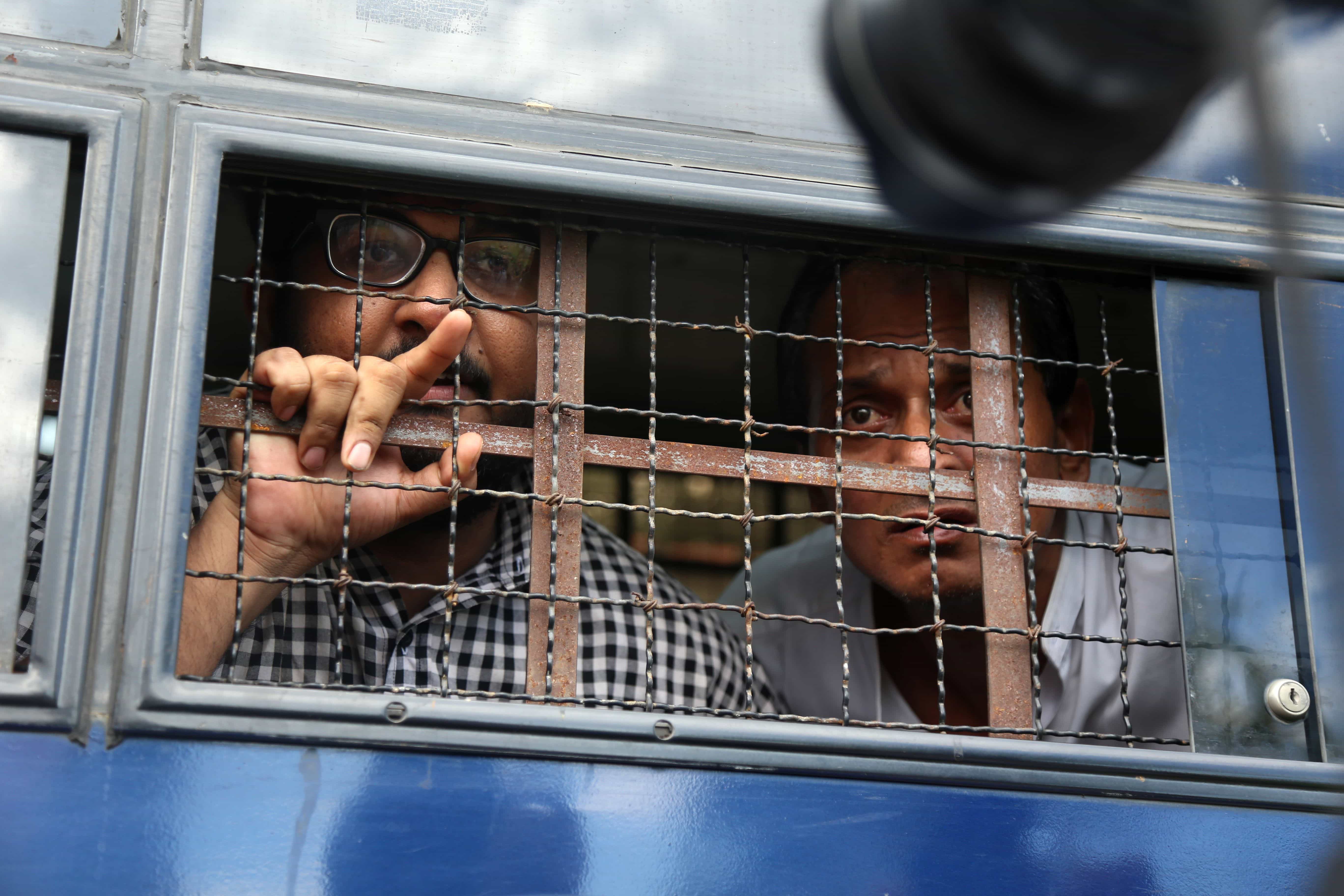 Burmese journalist Aung Naing Soe (L) and driver Hla Tin look out from a prison transport vehicle after being sentenced in November, AUNG HTET/AFP/Getty Images