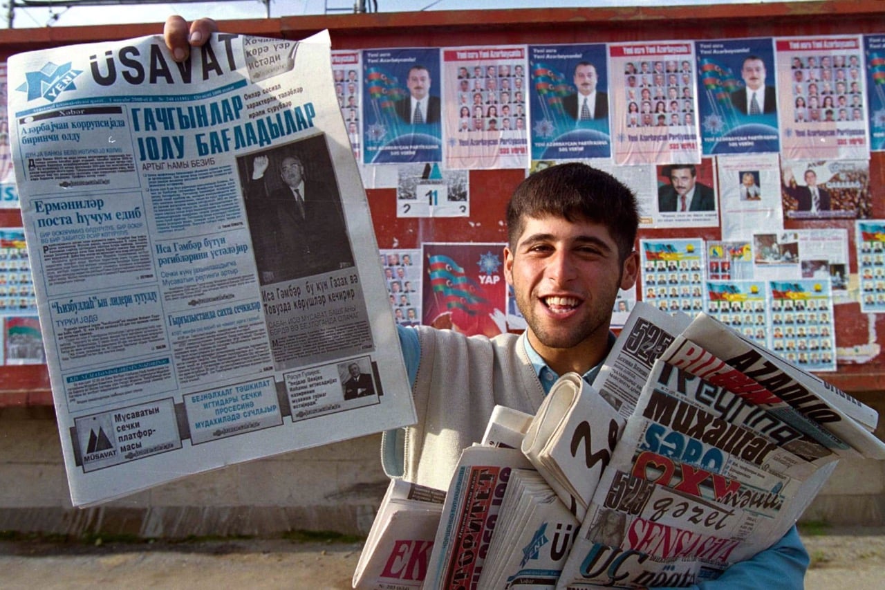 A newspaper vendor in Baku, Azerbaijan, 1 November 2000; in his left hand, he is holding a copy of "Azadliq" and other opposition papers, Reuters