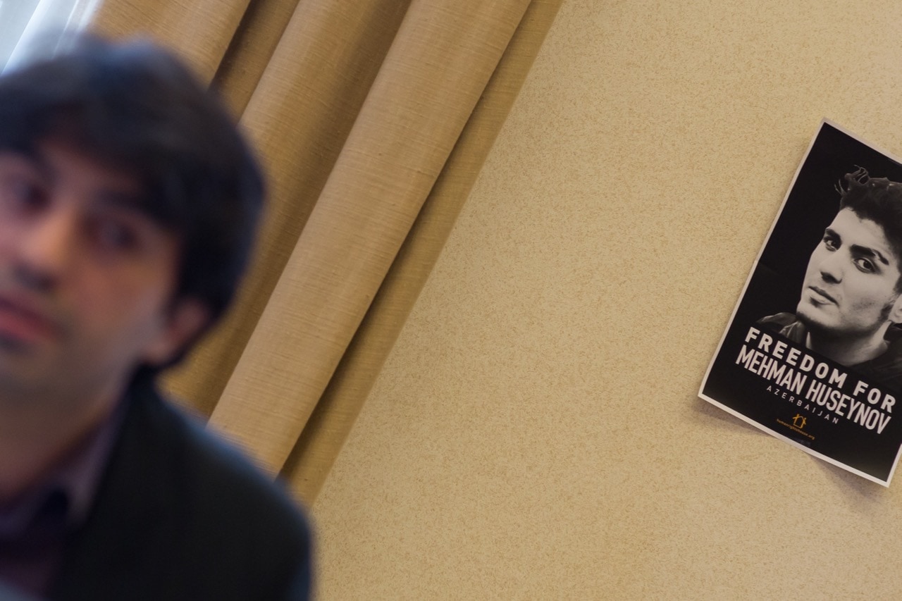 Emin Huseynov speaking at a side-event on human rights in Azerbaijan, with a poster of his brother Mehman Huseynov behind him, during the 34th session of the Human Rights Council in Geneva, 7 March 2017, UN Special Rapporteur Maina Kiai/HRC/Flickr