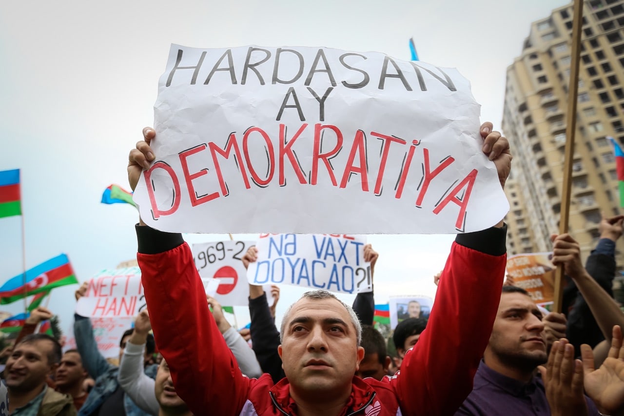 An Azerbaijani opposition supporter holds a placard reading 'Where is democracy?' during a protest against a scheduled referendum in Baku, 17 September 2016, Aziz Karimov/Pacific Press/LightRocket via Getty Images