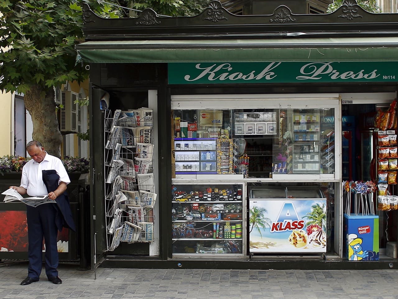 A man reads a newspaper near a kiosk in Baku, 15 June 2015, REUTERS/Stoyan Nenov