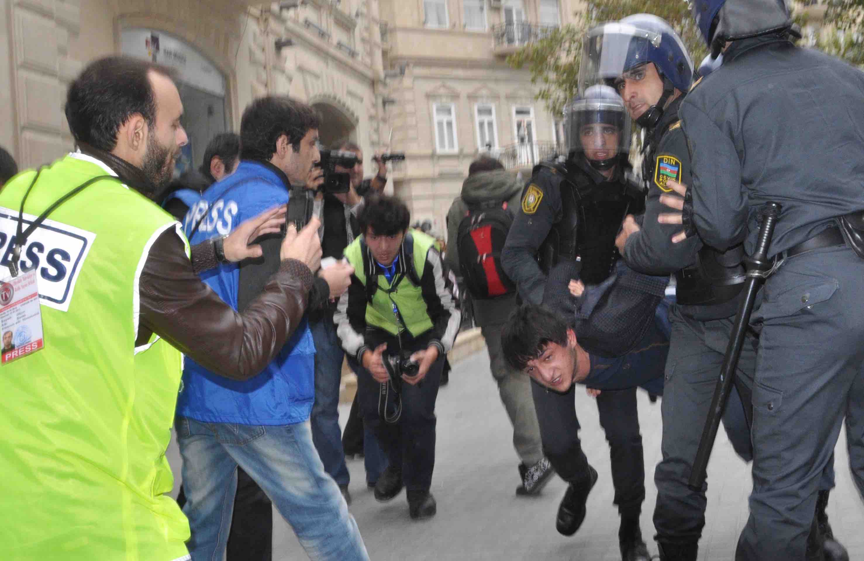 Rasim Aliyev (in yellow) covering a confrontation with police, IRFS