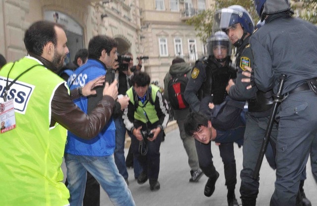 Rasim Aliyev (in yellow) covering a confrontation with police.,  IRFS