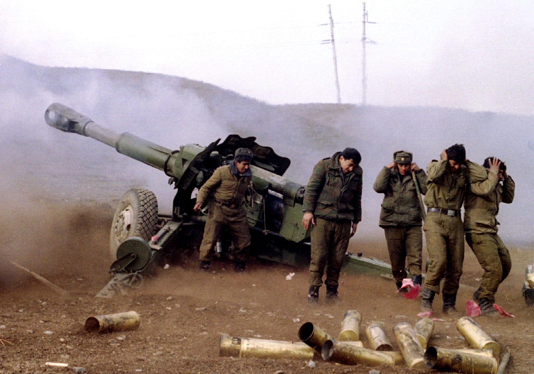 Azeri soldiers cover their ears as they fire a cannon at Armenian guerillas in outskirts of the town of Fizully on January 15, 1994, Reuters