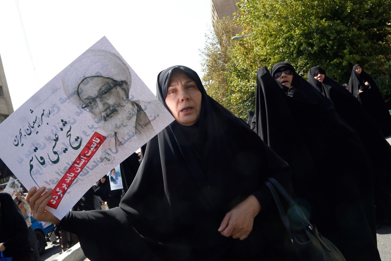 An Iranian woman holds a portrait of Bahraini Shiite cleric Sheikh Isa Qassim as she takes part with other women in an anti-Saudi demonstration in Tehran, Iran, 9 September 2016, STR/AFP/Getty Images