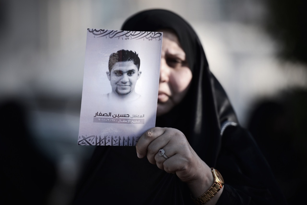 A Bahraini woman holds up a portrait of her jailed political activist relative during an anti-government protest in the village of Jannusan, west of the capital Manama, 19 September 2014, MOHAMMED AL-SHAIKH/AFP/Getty Images