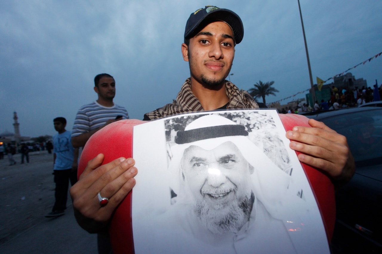 A young man holds a picture of Hassan Mushaima, General Secretary of opposition party Al Haq Movement, in Manama, Bahrain, 12 April 2009, REUTERS/Hamad I Mohammed (BAHRAIN POLITICS CONFLICT SOCIETY)