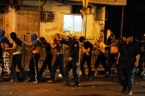 Bahraini policemen arrest protesters during a demonstration in the village of Bani Jamrah, BCHR