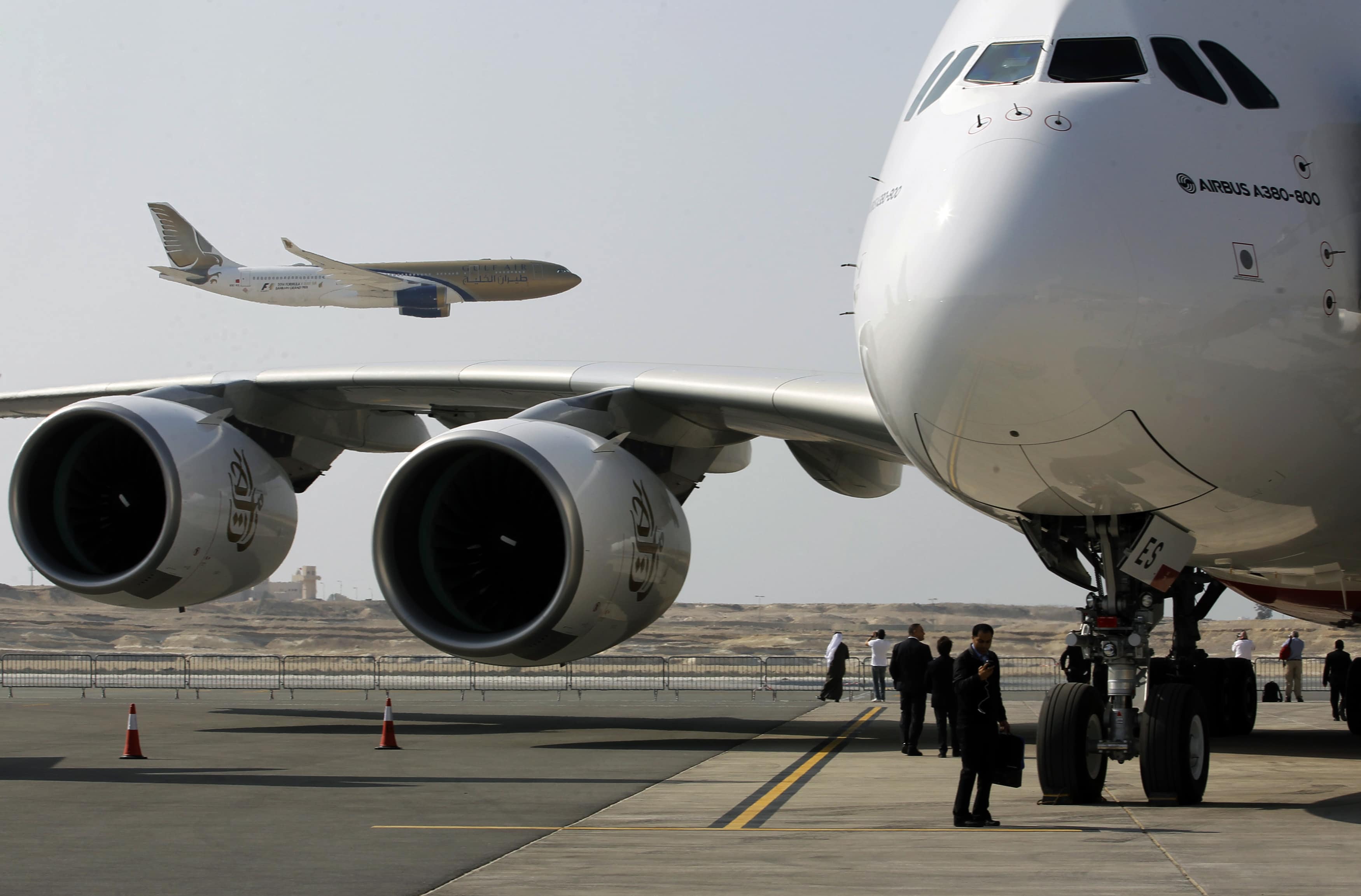 A GulfAir Airbus 330 aircraft flies over a parked Emirates Airline's Airbus A380 at the Sakir airbase south of Manama, REUTERS/Hamad I Mohammed