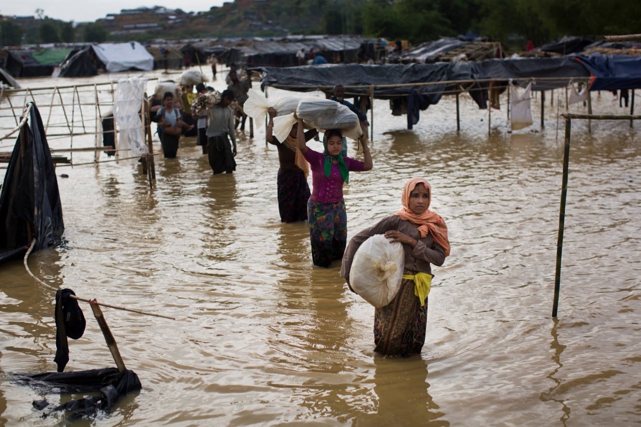 Rohingya Muslims, who crossed over recently from Burma into Bangladesh, carry their belongings and leave their flooded camp for alternate shelter near Cox's Bazar, Bangladesh, 19 September 2017, AP Photo/Bernat Armangue