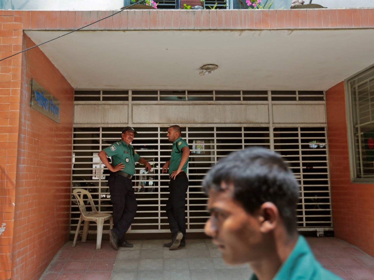 Policemen stand guard at the entrance to the building where activists Zulhaz Mannan and Tanay Fahim were stabbed to death in Dhaka, 26 April 2016, AP Photo