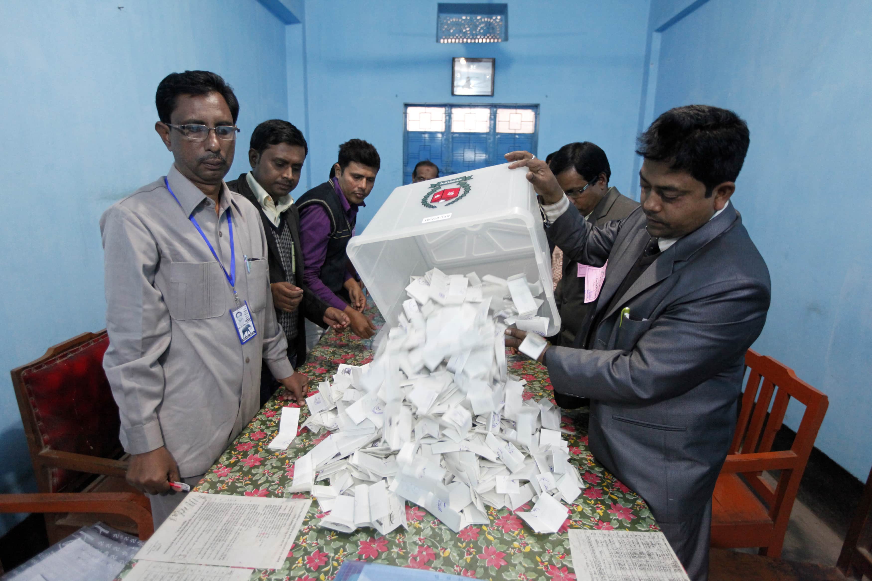 A polling officer pours ballot papers onto a table to be counted during parliamentary elections in Dhaka, 5 January 2014, REUTERS/Andrew Biraj