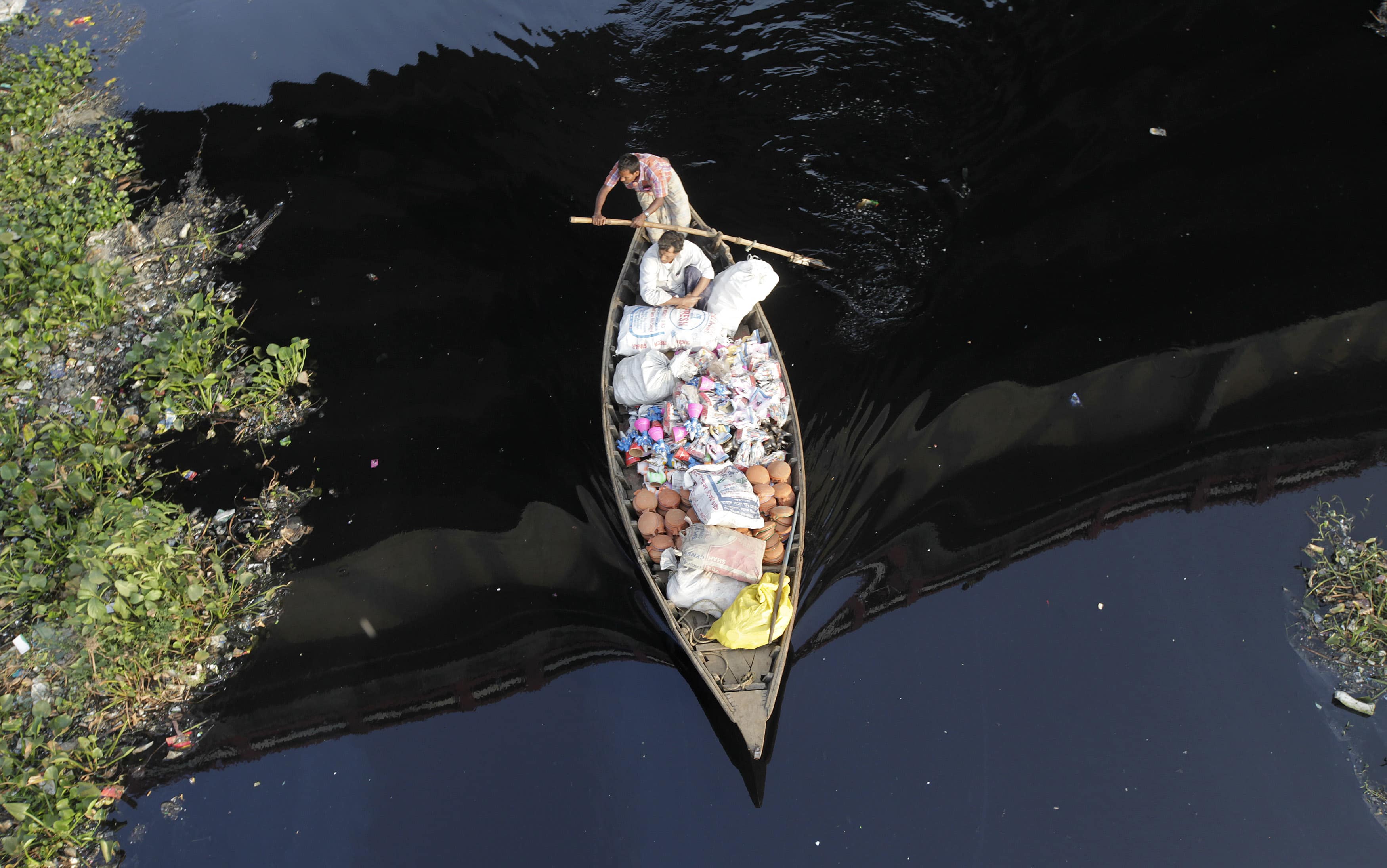 A boatman makes his way through the polluted water of the river Buriganga in Dhaka, 11 November 2012, REUTERS/Andrew Biraj