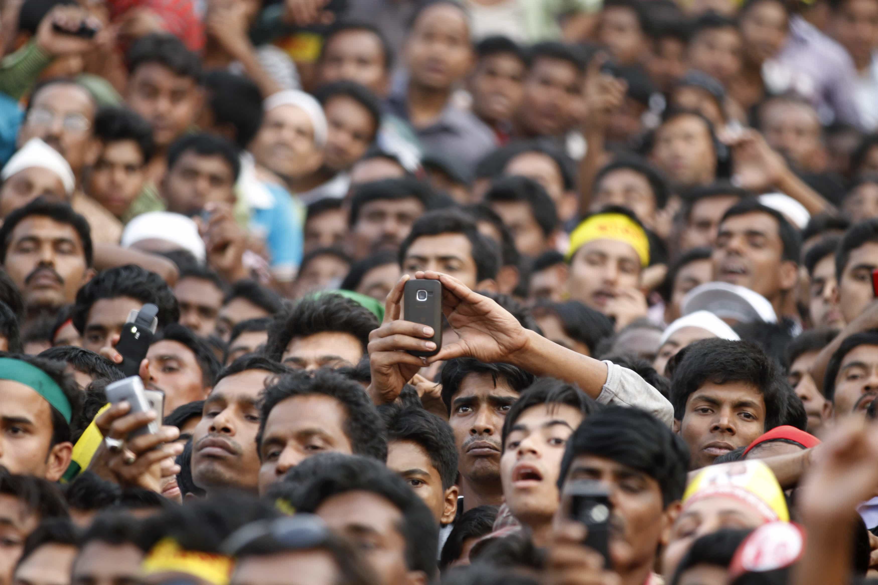 A supporter of Bangladesh Awami League takes pictures with a mobile phone during a rally in Dhaka, 14 March 2012, REUTERS/Andrew Biraj
