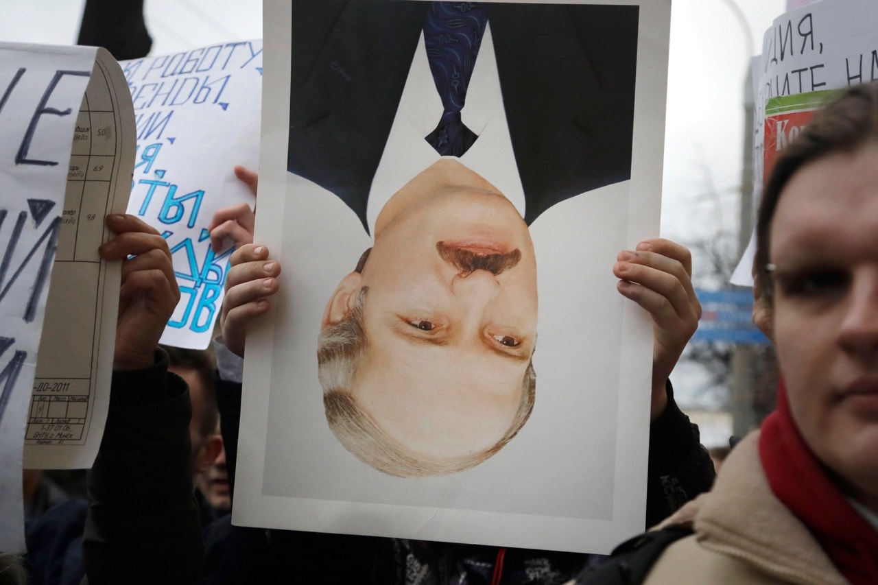 A protestor holds an overturned portrait of Belorussian President Alexander Lukashenko during a rally in Minsk, Belarus, 15 March 2017, AP Photo/Sergei Grits