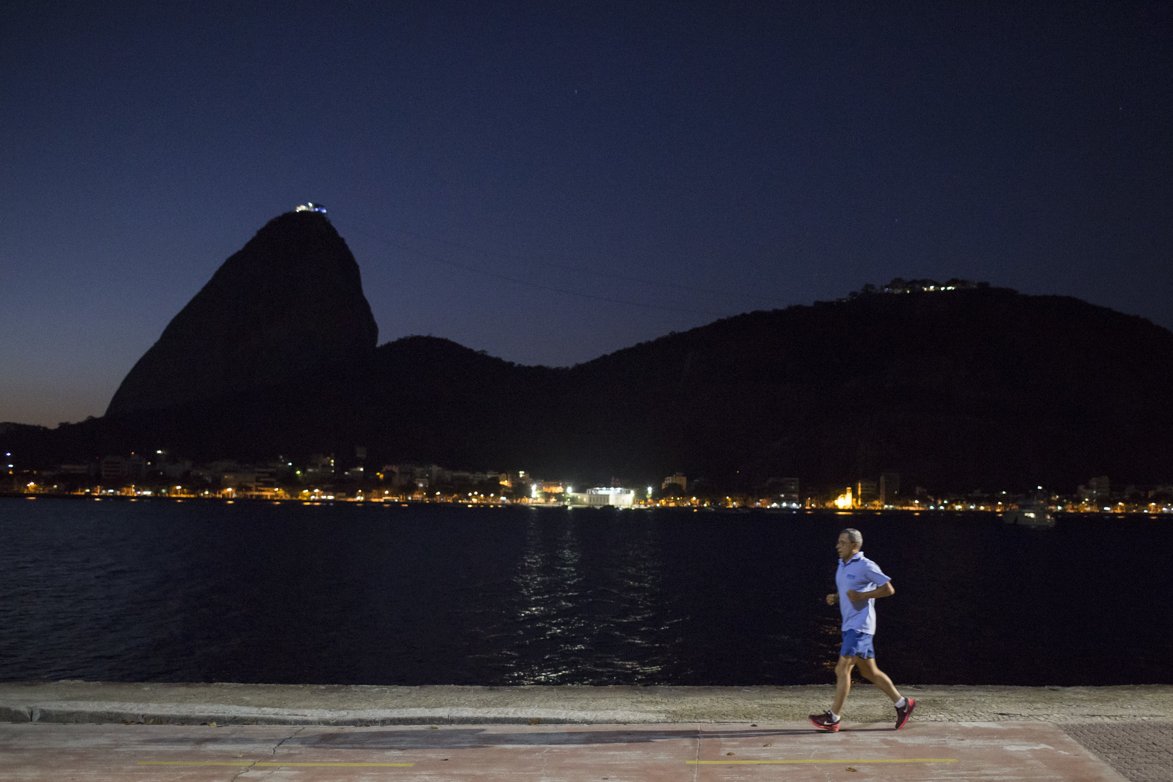 A man exercises at dawn in Flamengo beach, next to Guanabara Bay in Rio de Janeiro, Brazil, AP Photo/Felipe Dana