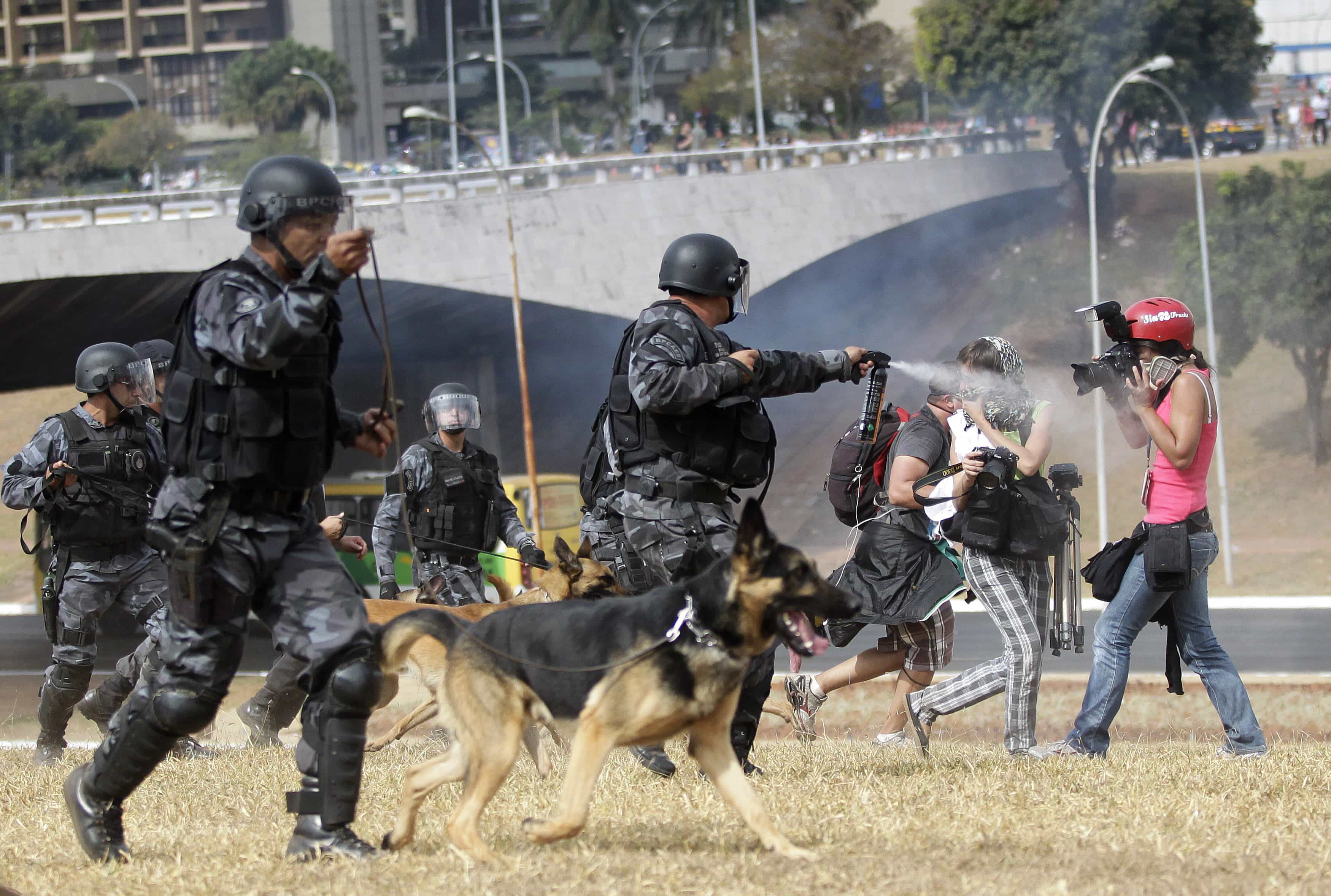 A riot police officer uses a pepper spray on photographers during a protest near Mane Guarrincha stadium in Brasilia, 7  September 2013. , REUTERS/Ueslei Marcelino