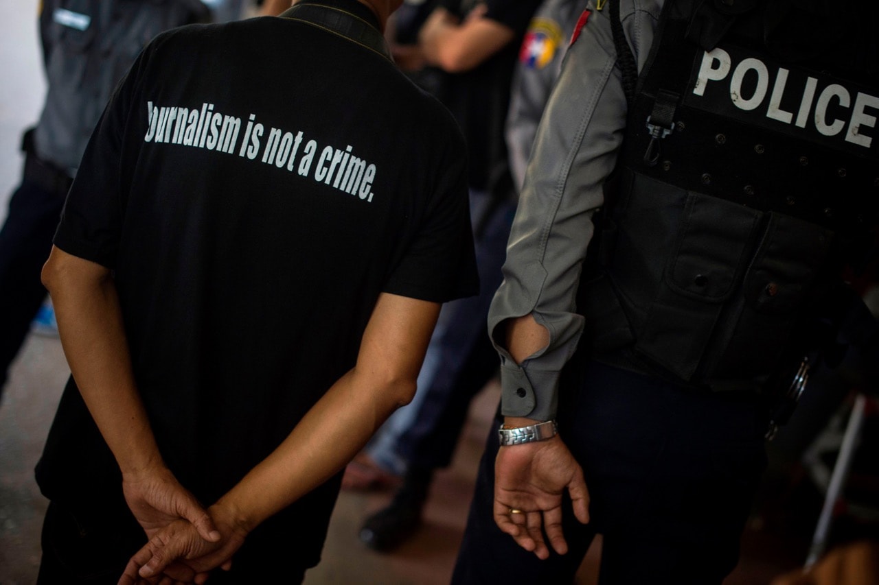 A local journalist (L) stands next to a police officer as Reuters journalists Kyaw Soe Oo and Wa Lone appear in court in Yangon, Burma, 10 January 2018, YE AUNG THU/AFP/Getty Images