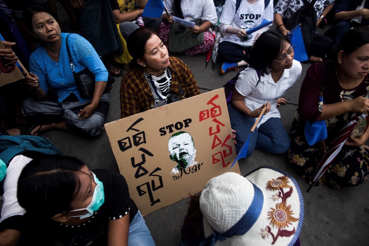 A demonstrator displays a poster during an anti-war protest in Yangon, Burma, 12 May 2018, SAI AUNG MAIN/AFP/Getty Images