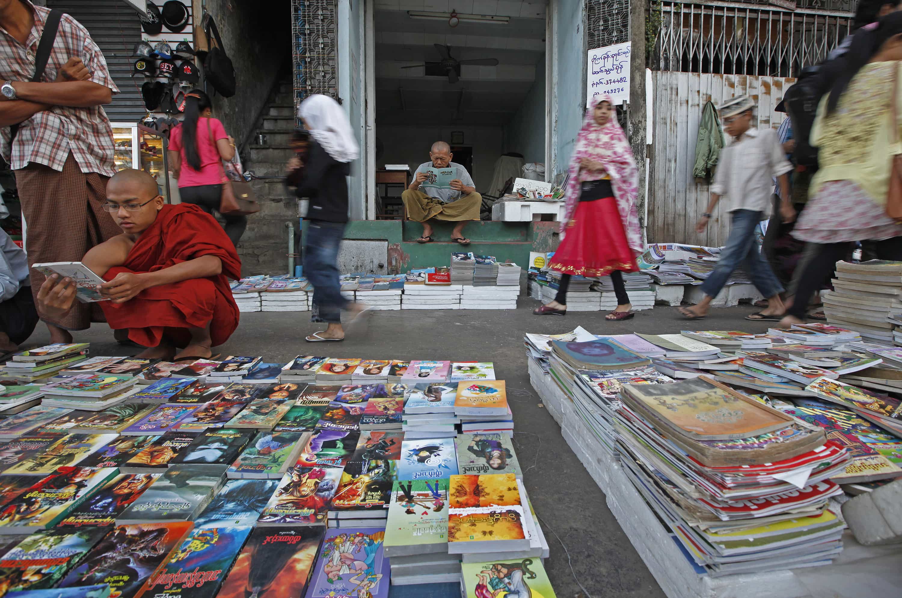 People read at a bookshop on a street in Yangon, 12 January 2013, REUTERS/Minzayar