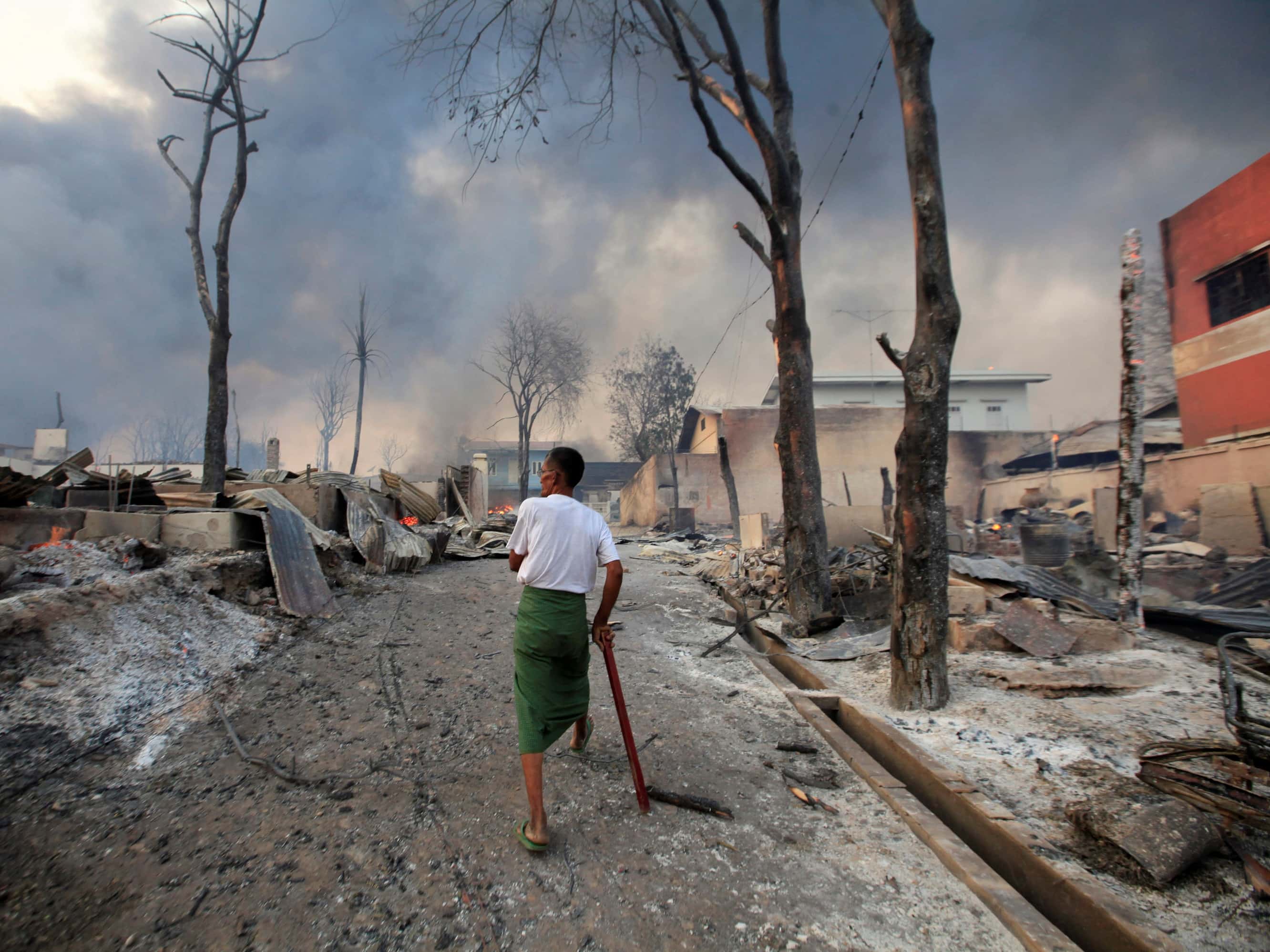 A man walks through a burned-out area of Meikhtila on 21 March 2013, REUTERS/Soe Zeya Tun