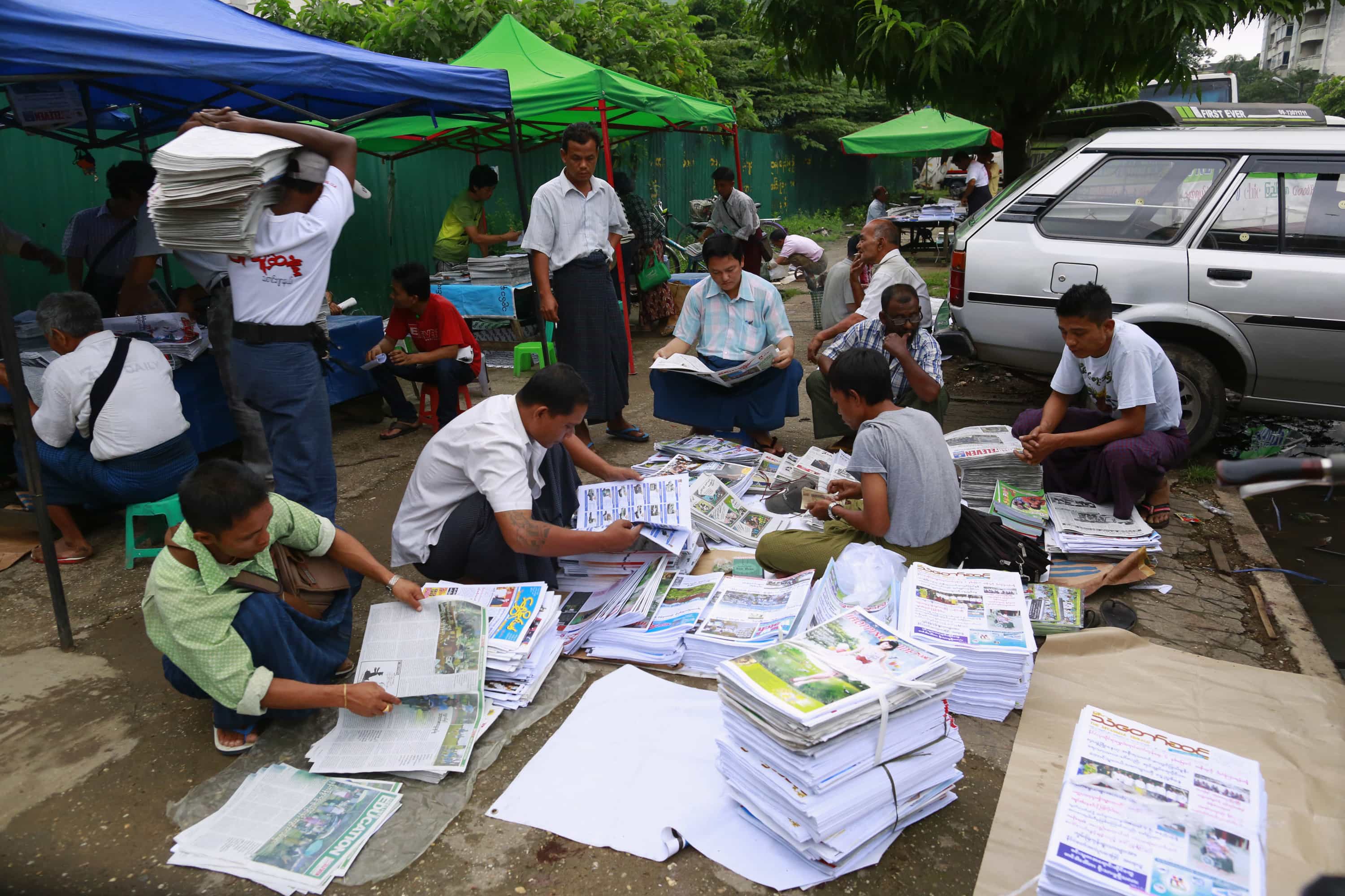 Men arrange stacks of papers at a newspaper wholesale market in Yangon, 6 September 2013, REUTERS/Soe Zeya Tun