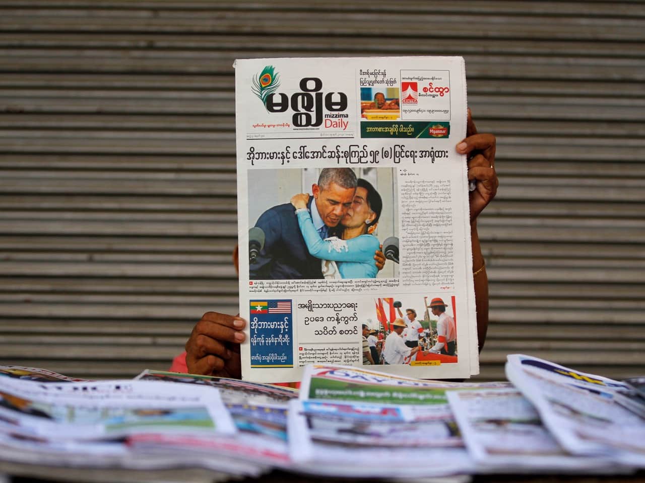 A woman shows a Mizzima newspaper at a newspaper wholesale market in Yangon, 15 November 2014 , REUTERS/Soe Zeya Tun