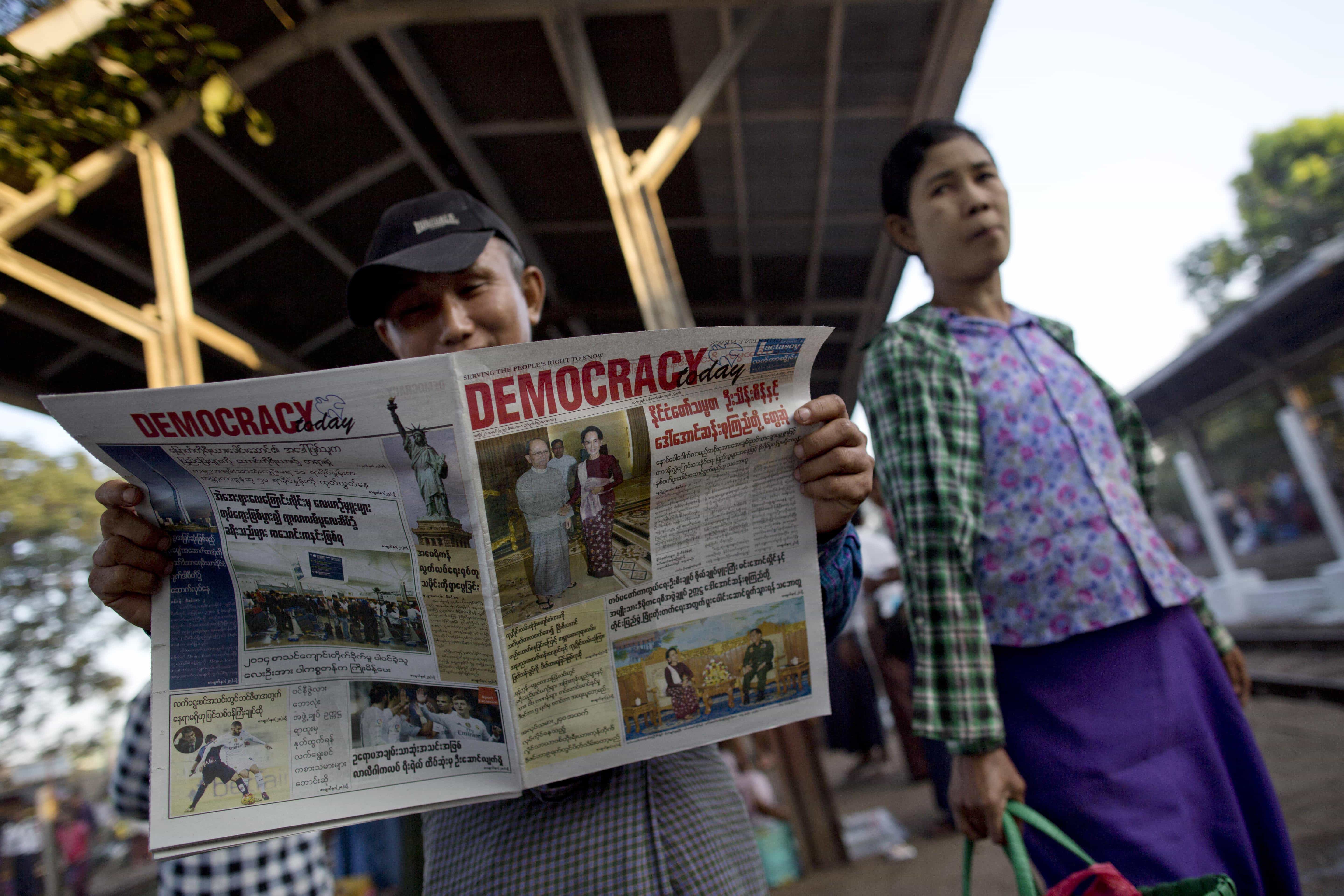 A man in a railway station in Yangon reads a newspaper featuring Aung San Suu Kyi's meetings with President Thein Sein and Gen. Min Aung Hlaing, the military commander-in-chief, 3 December 2015, AP Photo/ Gemunu Amarasinghe