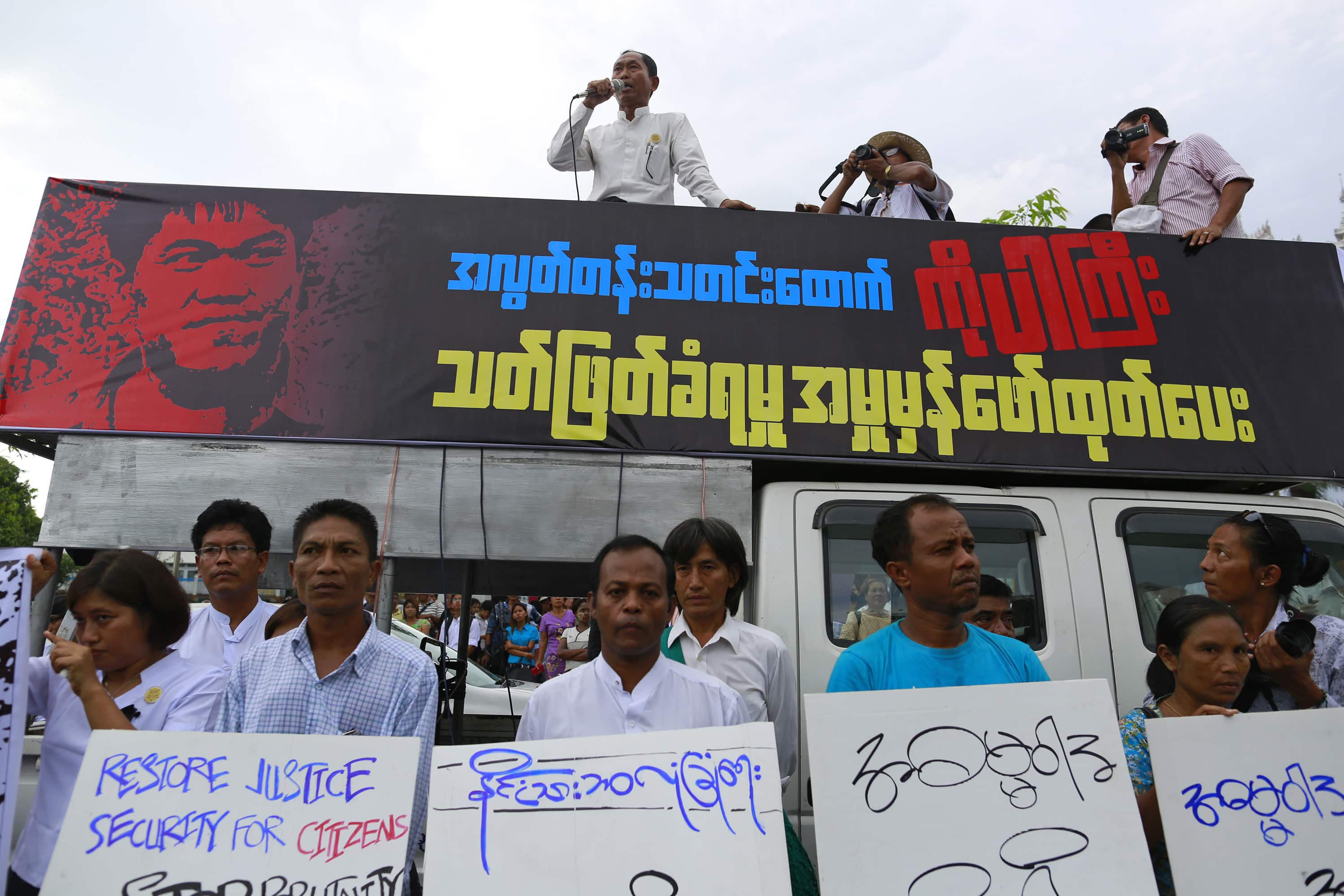 Ko Ko Gyi, a leader of the 88 Generation Students group, speaks as political activists hold placards during a demonstration for reporter Aung Kyaw Naing (also known as Ko Par Gyi) in Yangon, 26 October 2014, REUTERS/Soe Zeya Tun