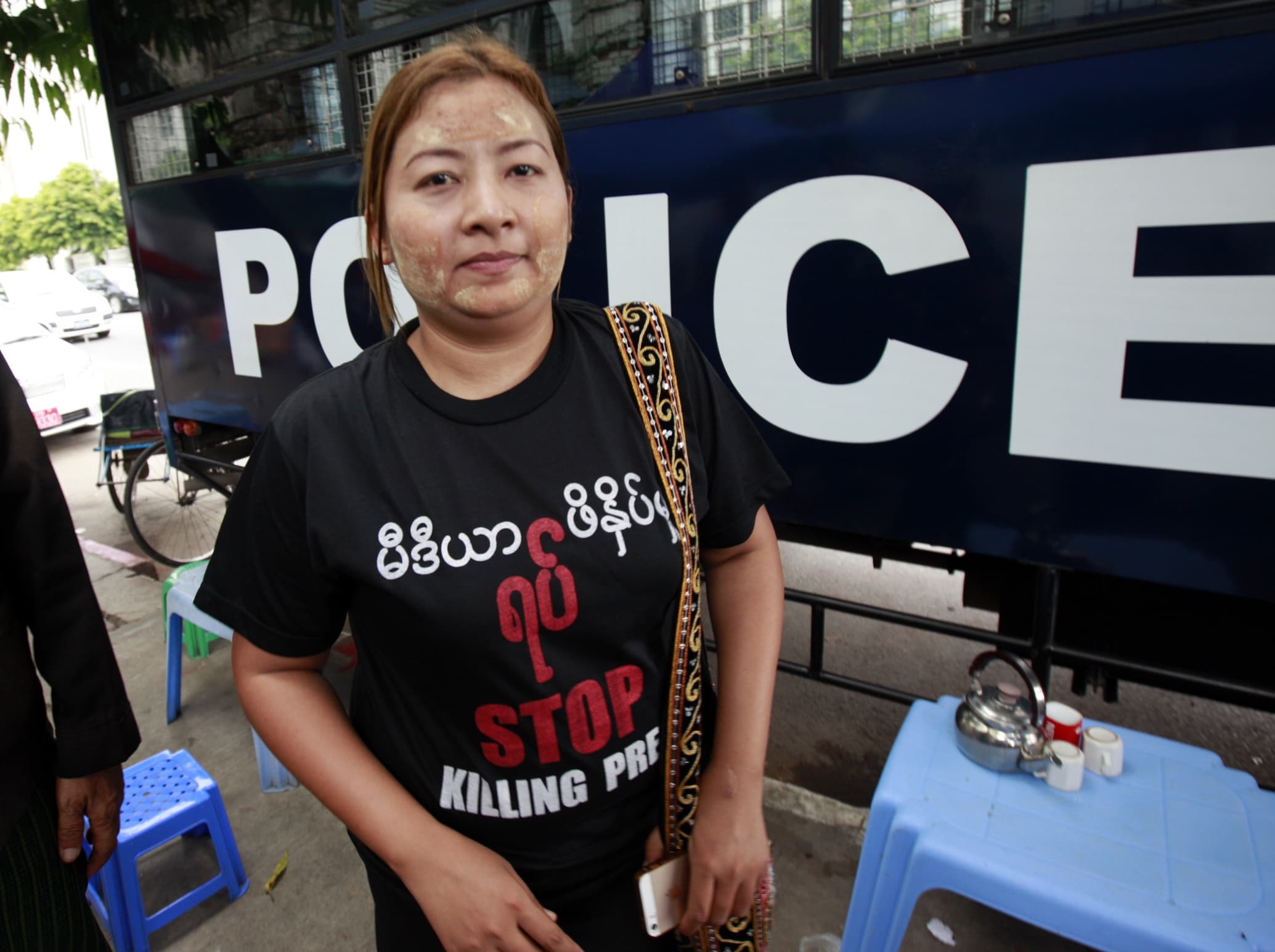 Reporter Shwe Hmone stands near a police truck as she waits to face her trial at a township court on 8 June 2015, in Yangon, AP Photo/Khin Maung Win