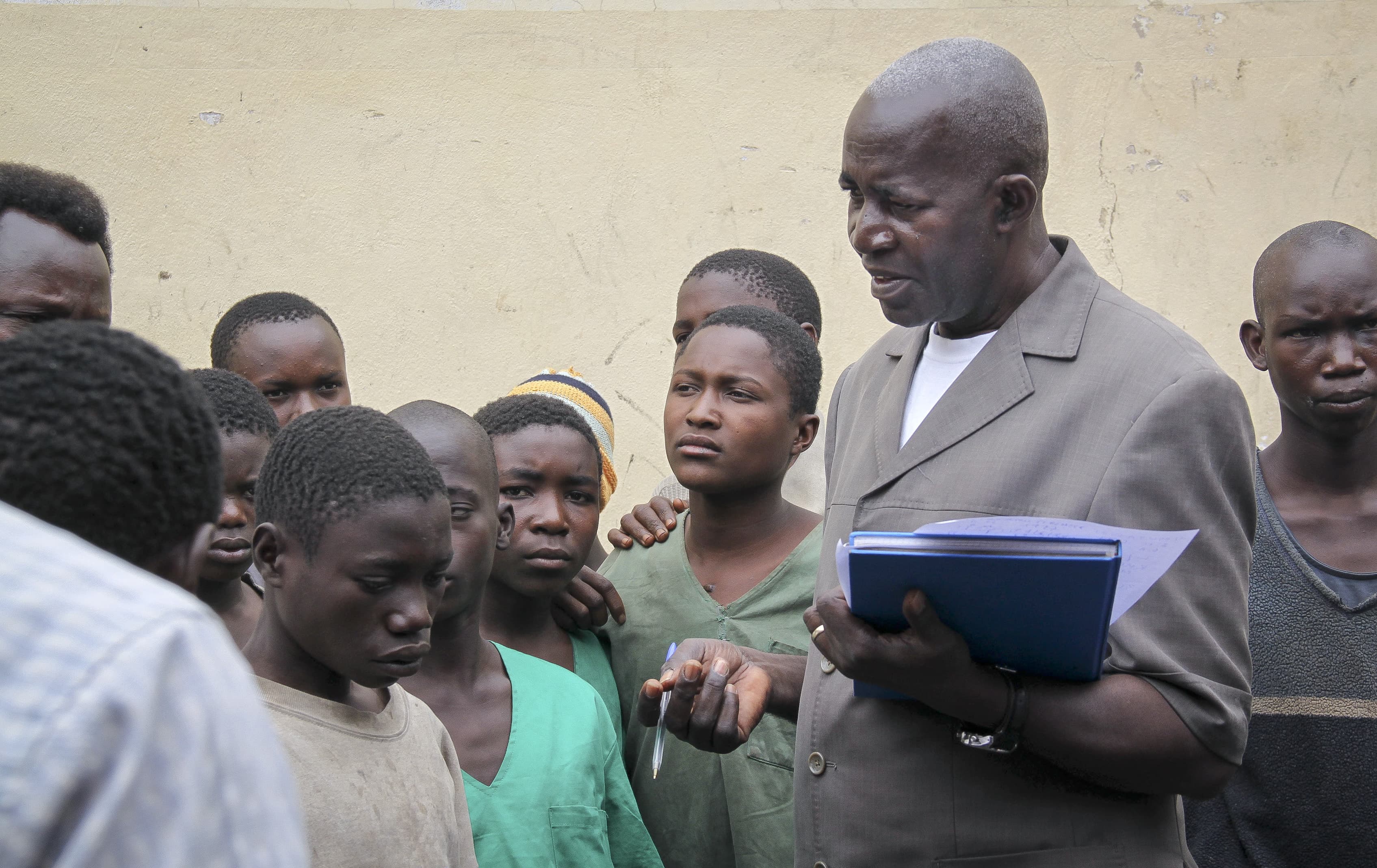 In this undated photo, prominent Burundian rights activist Pierre Claver Mbonimpa, center-right, visits with prisoners in Bujumbura, AP Photo