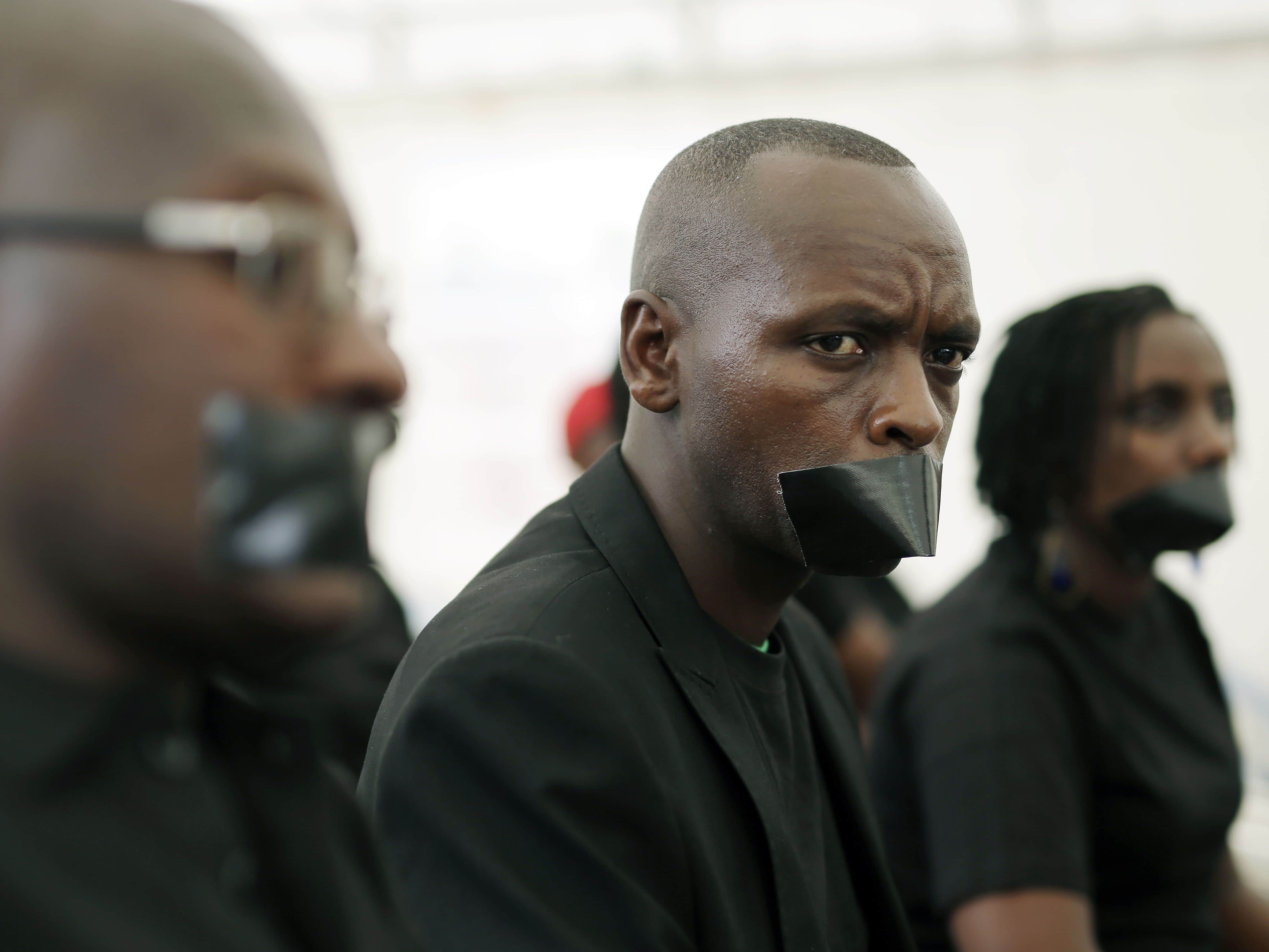 Journalists with tape on their mouths gather on the occasion of World Press Freedom Day in Bujumbura, Burundi, 3 May 2015, AP Photo/Jerome Delay