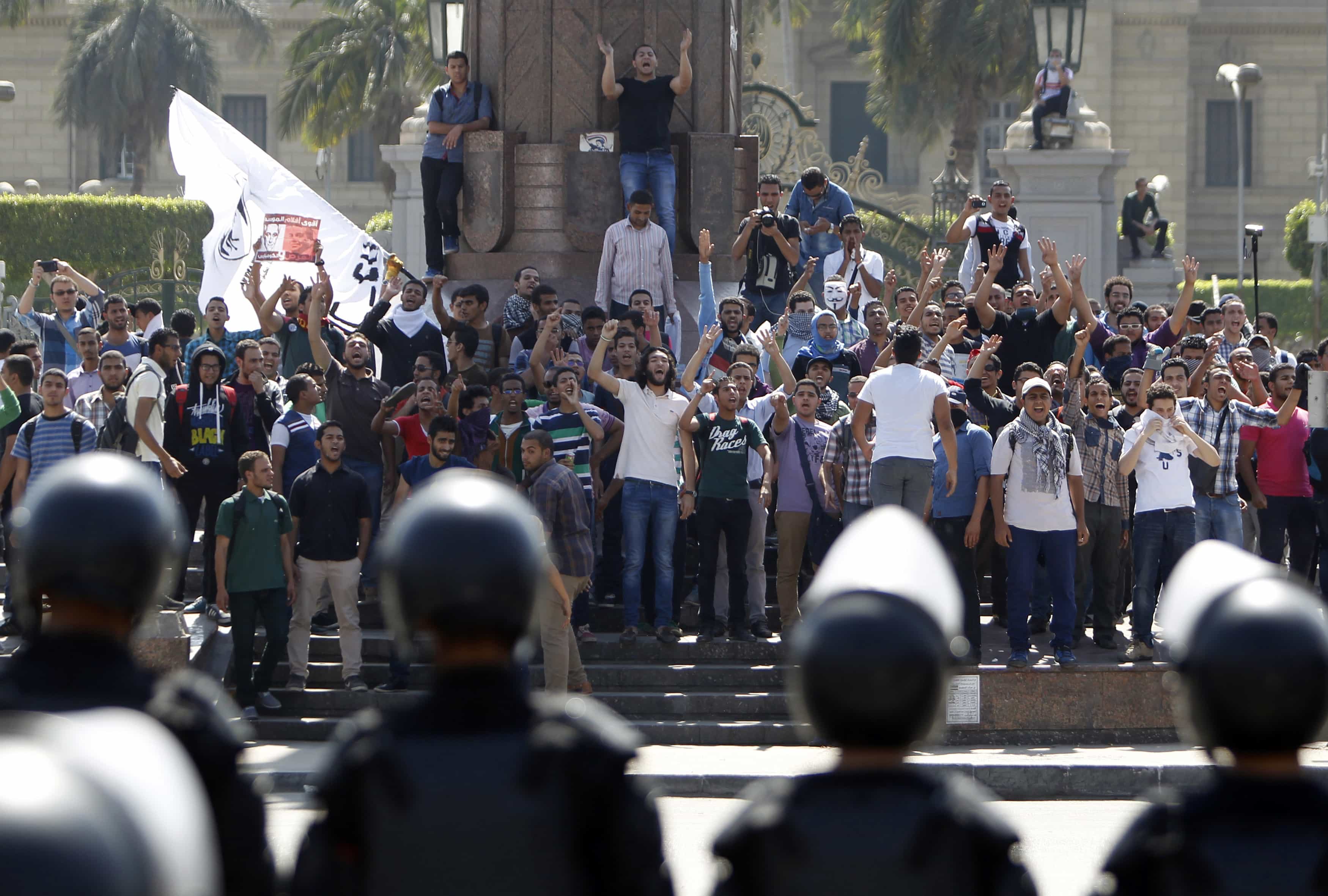 Student supporters of the Muslim Brotherhood shout slogans as they face a line of riot police during a demonstration outside Cairo University on 14 May 2014, REUTERS/Mohamed Abd El Ghany