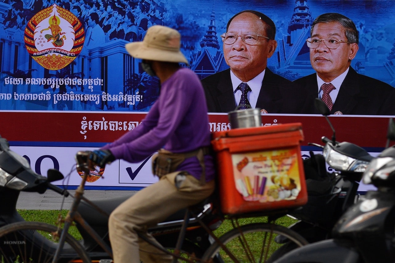 A cyclist rides past an electoral advertisement for Prime Minister Hun Sen, in Phnom Penh, Cambodia, 26 July 2018, MANAN VATSYAYANA/AFP/Getty Images