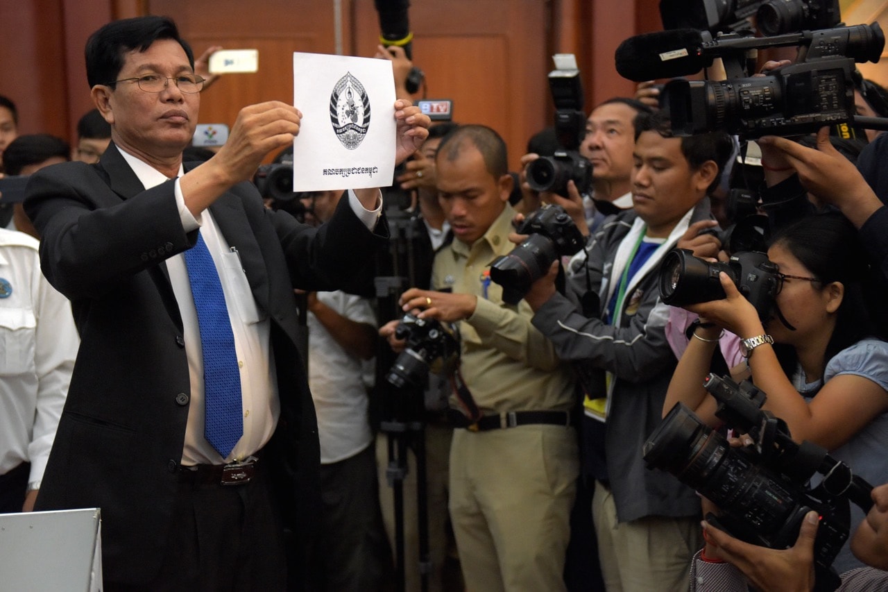 A Cambodian National Election Committee officer shows the logo of the ruling Cambodian People's Party (CPP) to journalists during a draw ceremony in Phnom Penh, 29 May 2018 to determine the order in which political parties are listed on the ballots for the national election in July, TANG CHHIN SOTHY/AFP/Getty Images