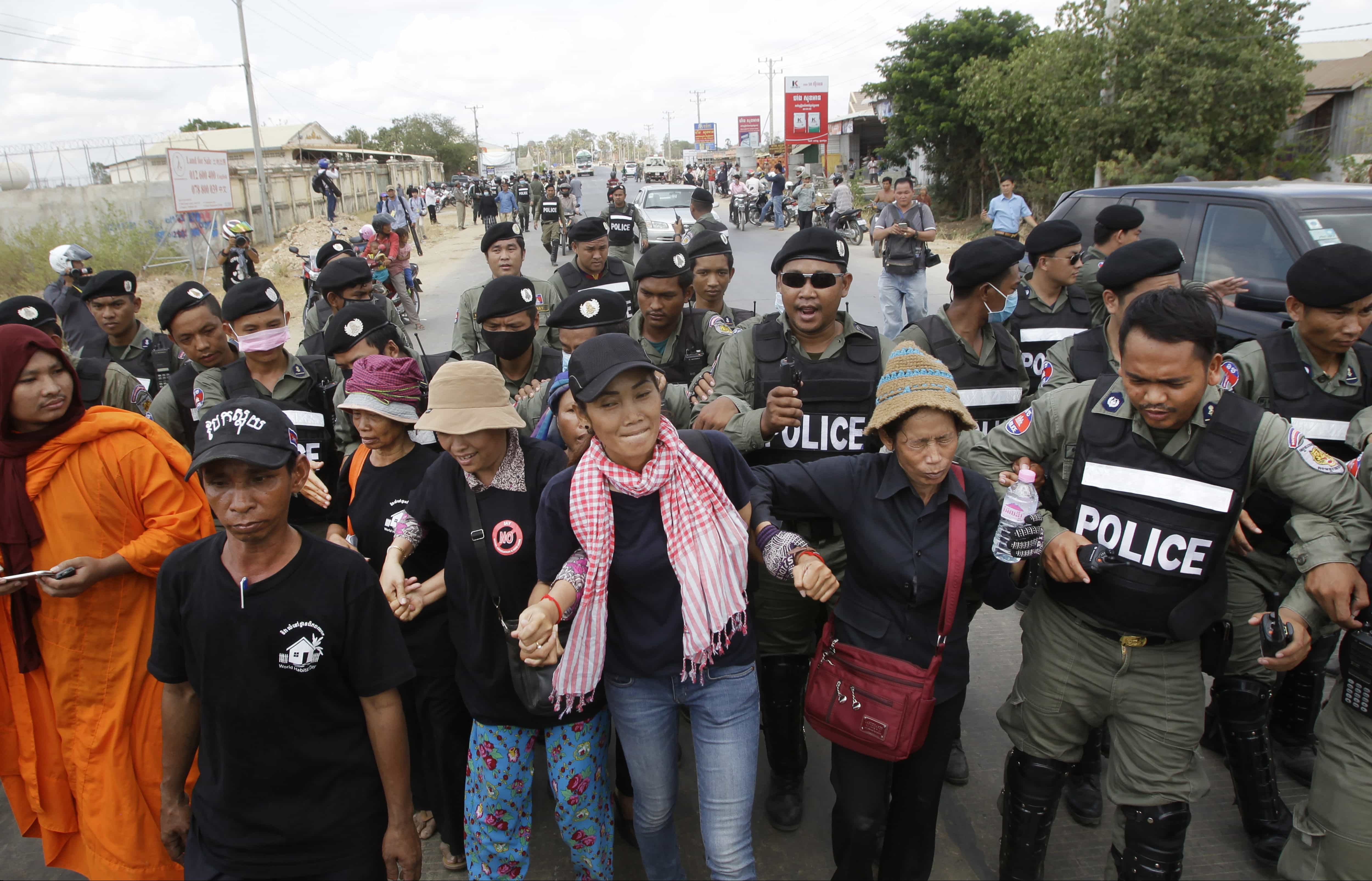 Cambodian civil rights supporters are forcibly directed by riot police as they march in protest of charges brought against local rights activists near Prey Sar prison, Cambodia, 9 May 2016, AP Photo/Heng Sinith