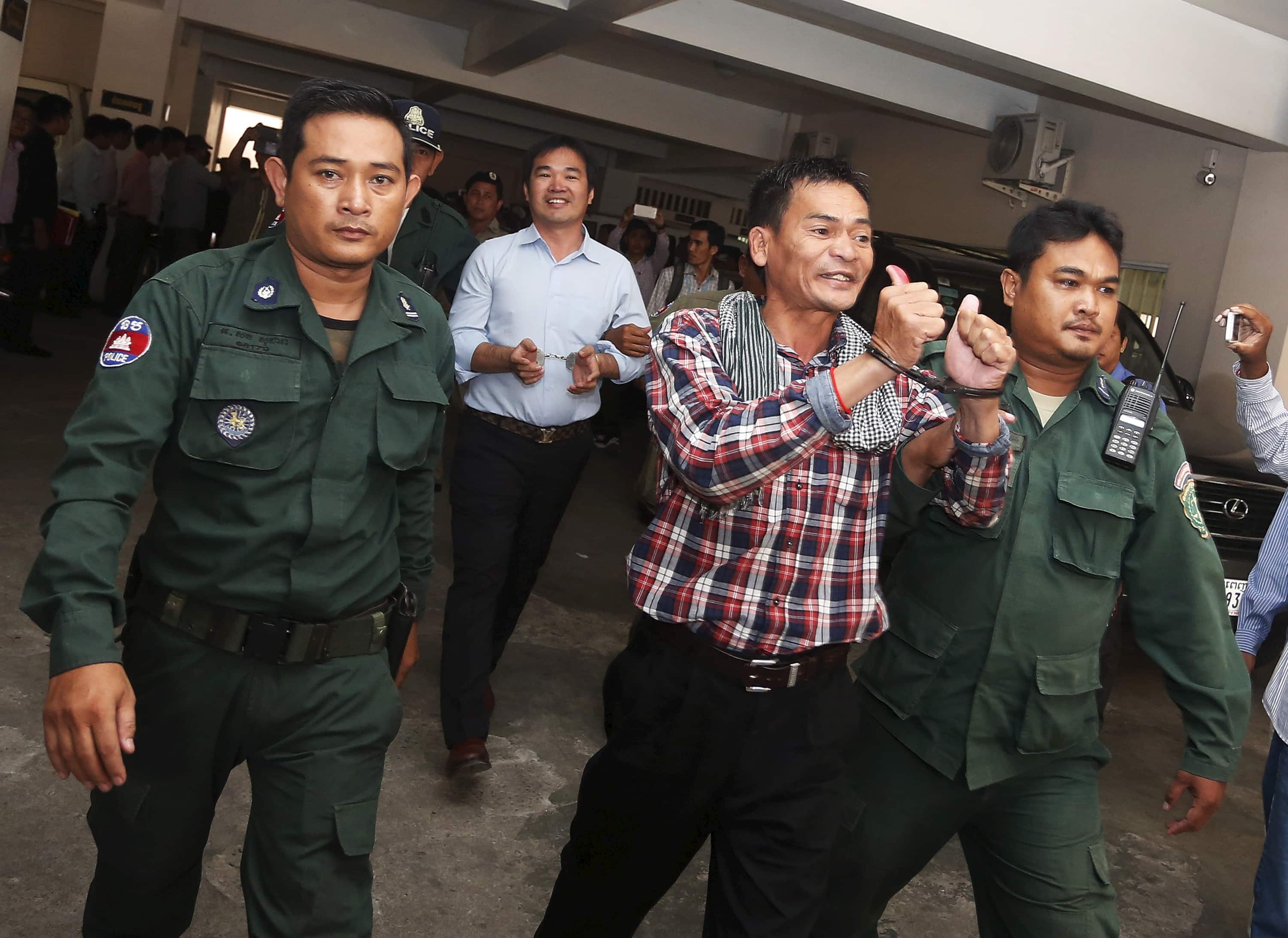 Supporters of the Cambodia National Rescue Party (CNRP) are escorted by police officers at the Phnom Penh Municipal Court, 21 July 2015, REUTERS/Stringer