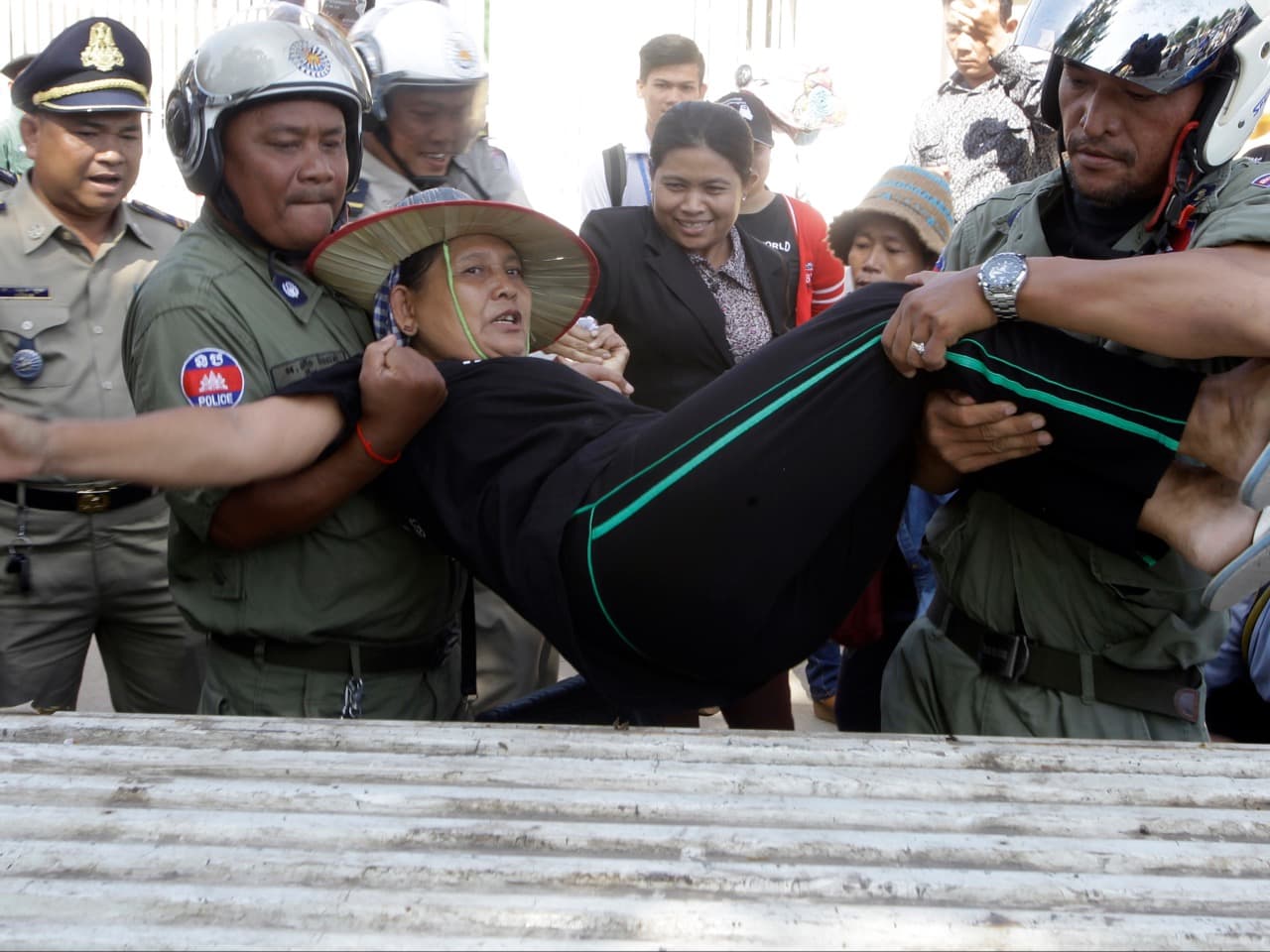 Riot police load an activist onto a truck during a protest against the detention of local human rights activists outside of an appeals court in Phnom Penh, 13 June 2016, AP Photo/Heng Sinith