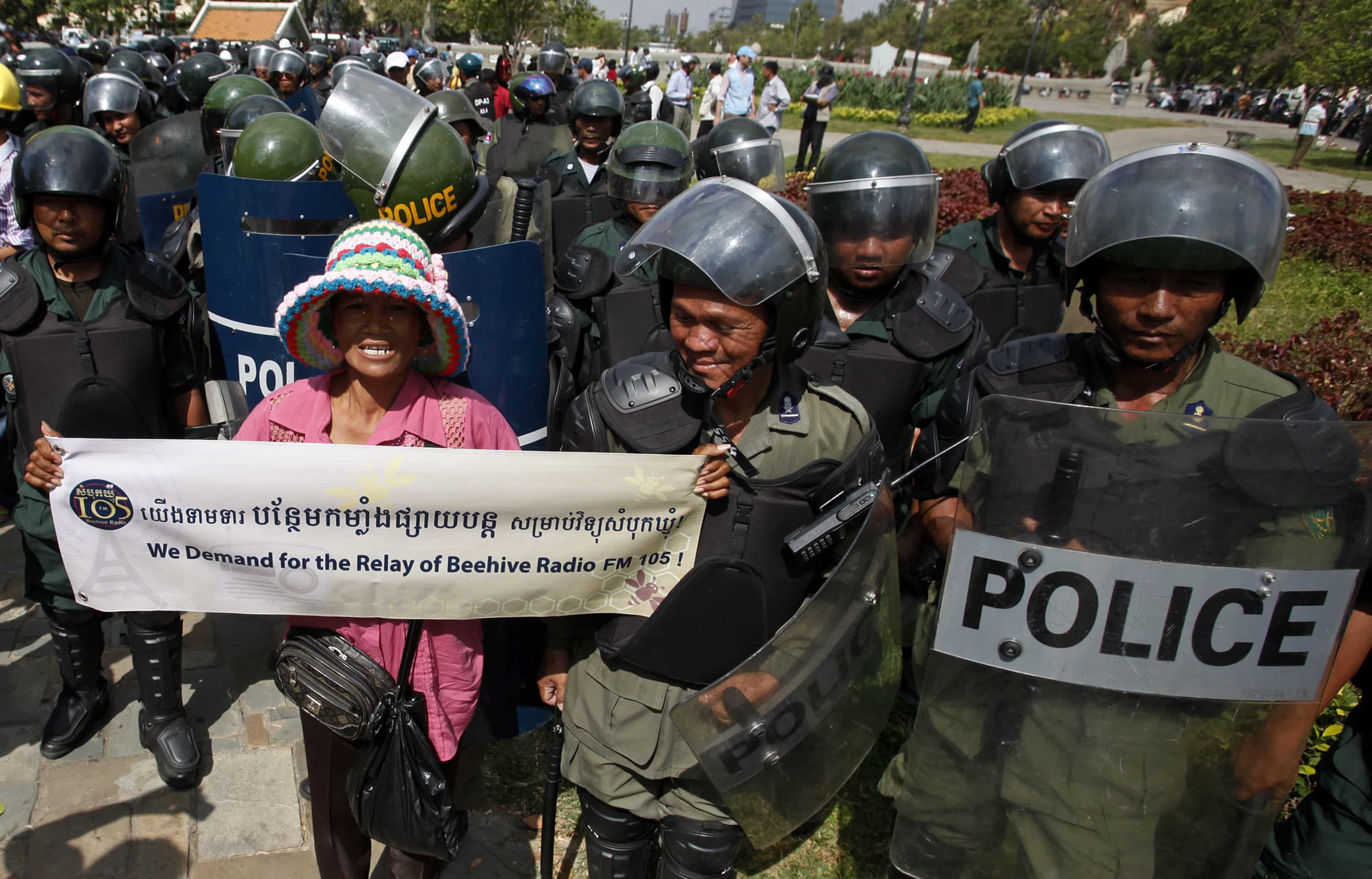 A protester is blocked by police officers during a 31 March 2014 demonstration in Phnom Penh that breached the ban on public gatherings, REUTERS/Samrang Pring