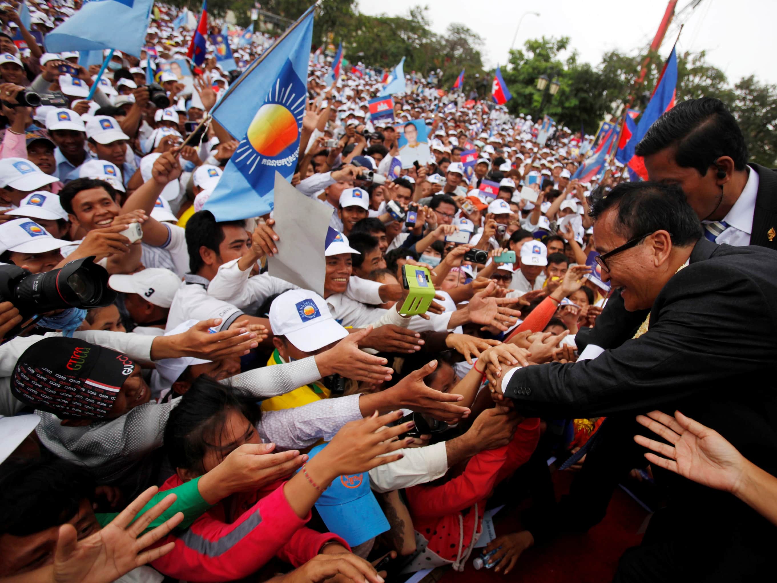 Sam Rainsy (R), president of the National Rescue Party, greets his supporters at the Freedom Park in Phnom Penh, 19 July 2013, REUTERS/Samrang Pring