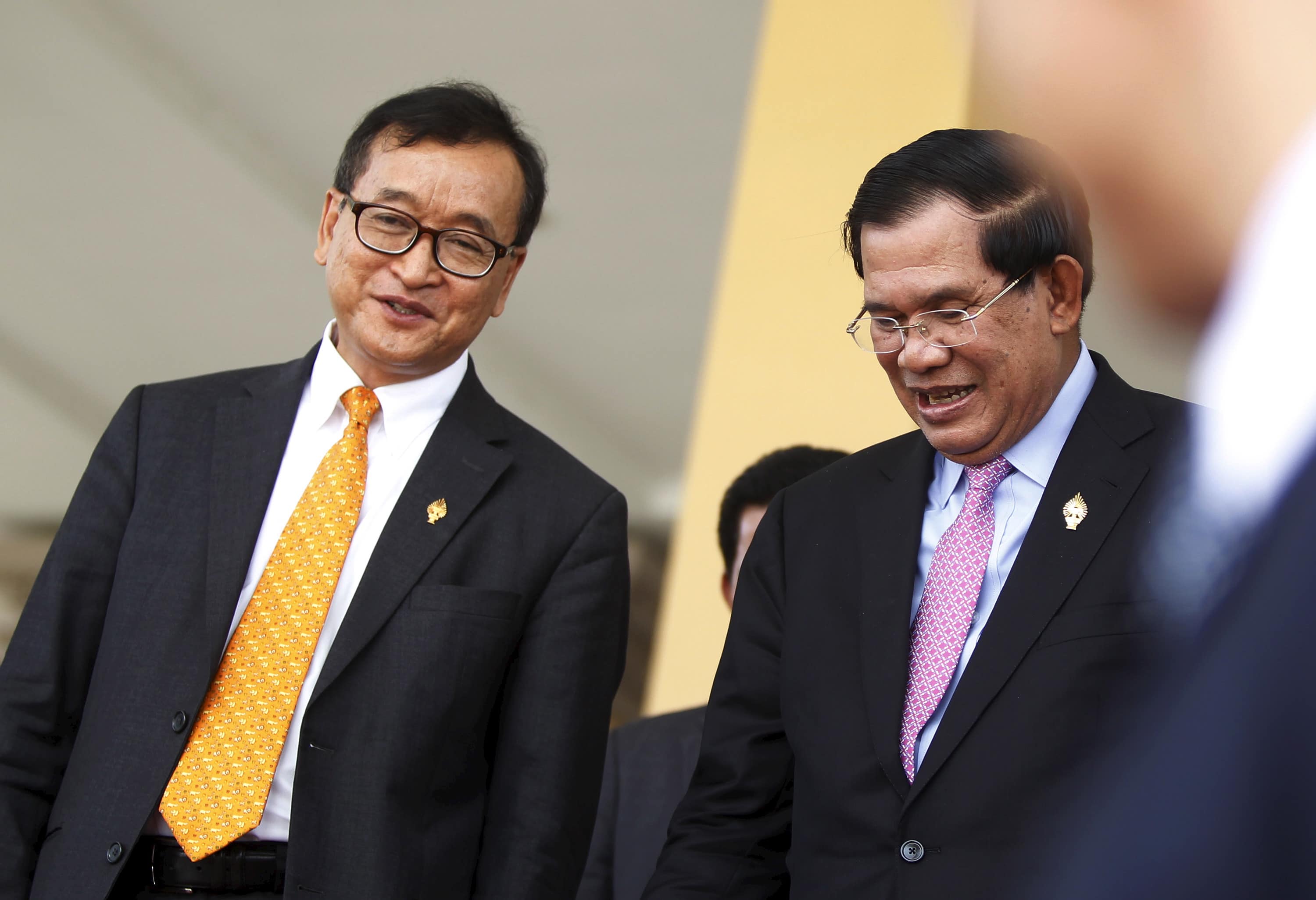 Cambodia's Prime Minister Hun Sen (R) and Sam Rainsy, president of the Cambodia National Rescue Party (CNRP), smile after a plenary session at the National Assembly in Phnom Penh, 9 April 2015, REUTERS/Samrang Pring