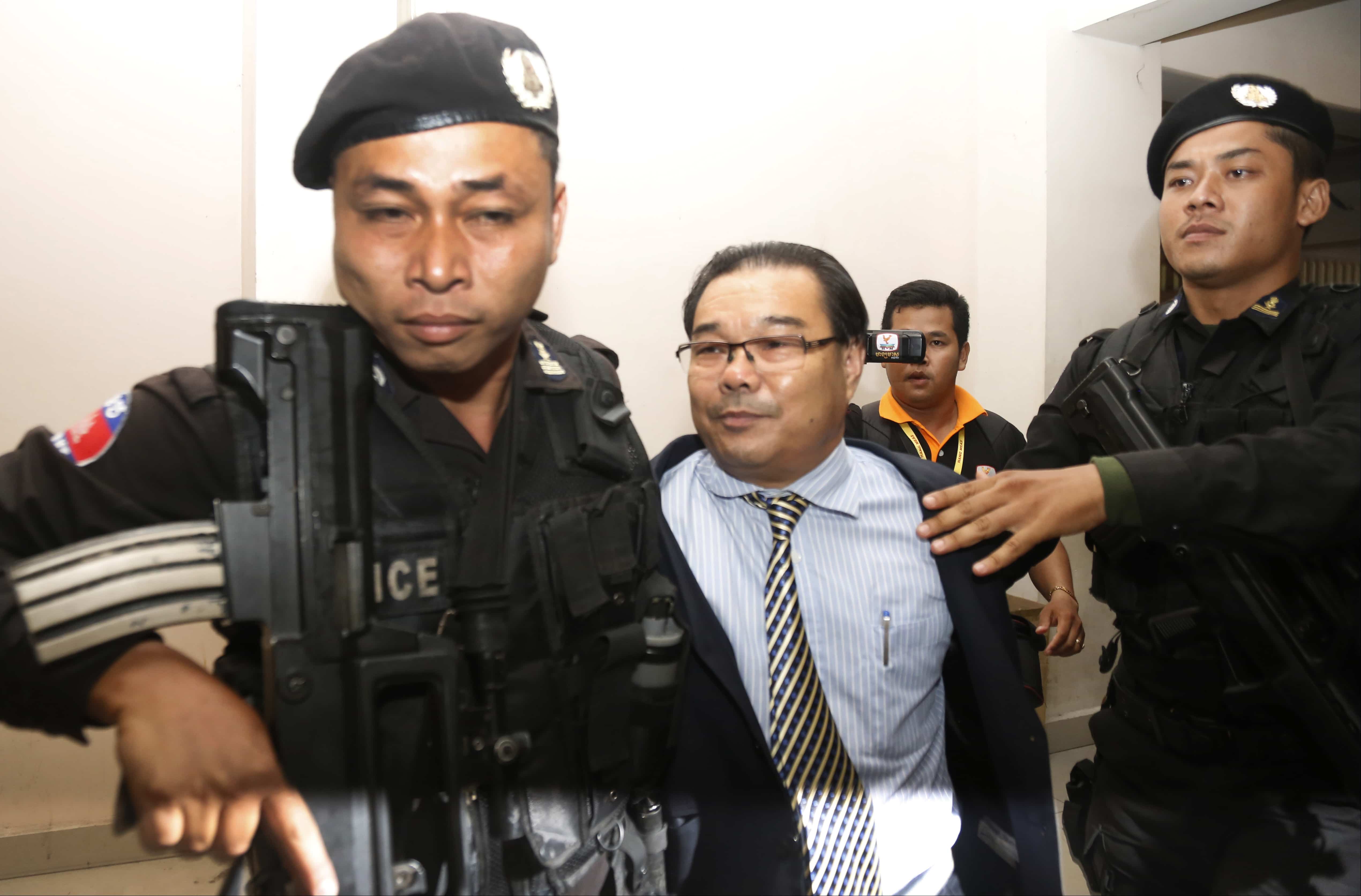 Opposition senator Hong Sok Hour, center, is escorted by riot police officers at Phnom Penh Municipal Court after the Prime Minister accused him of treason for comments posted on Facebook, AP Photo/Heng Sinith